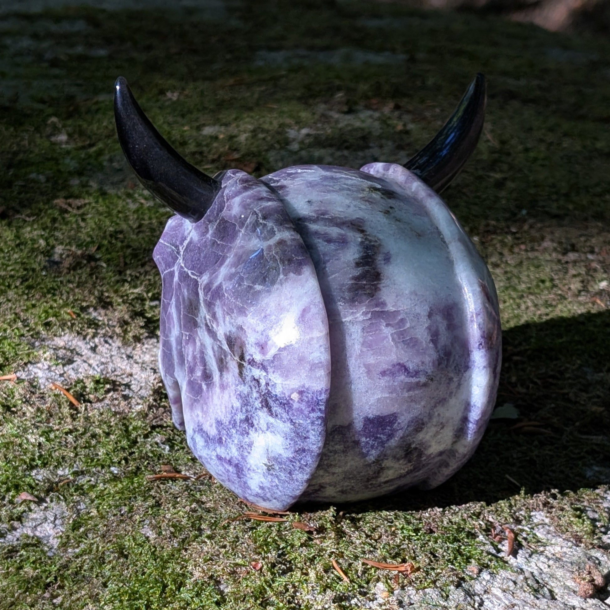 Kristallschädel "Schattenfürst" aus Amethyst mit schwarzen Obsidian-Hörnern.