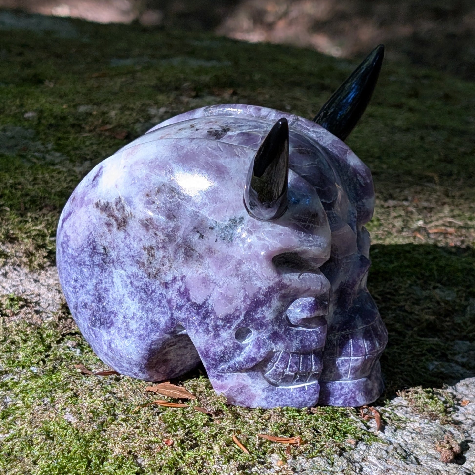 Kristallschädel "Schattenfürst" aus Amethyst mit schwarzen Obsidian-Hörnern.