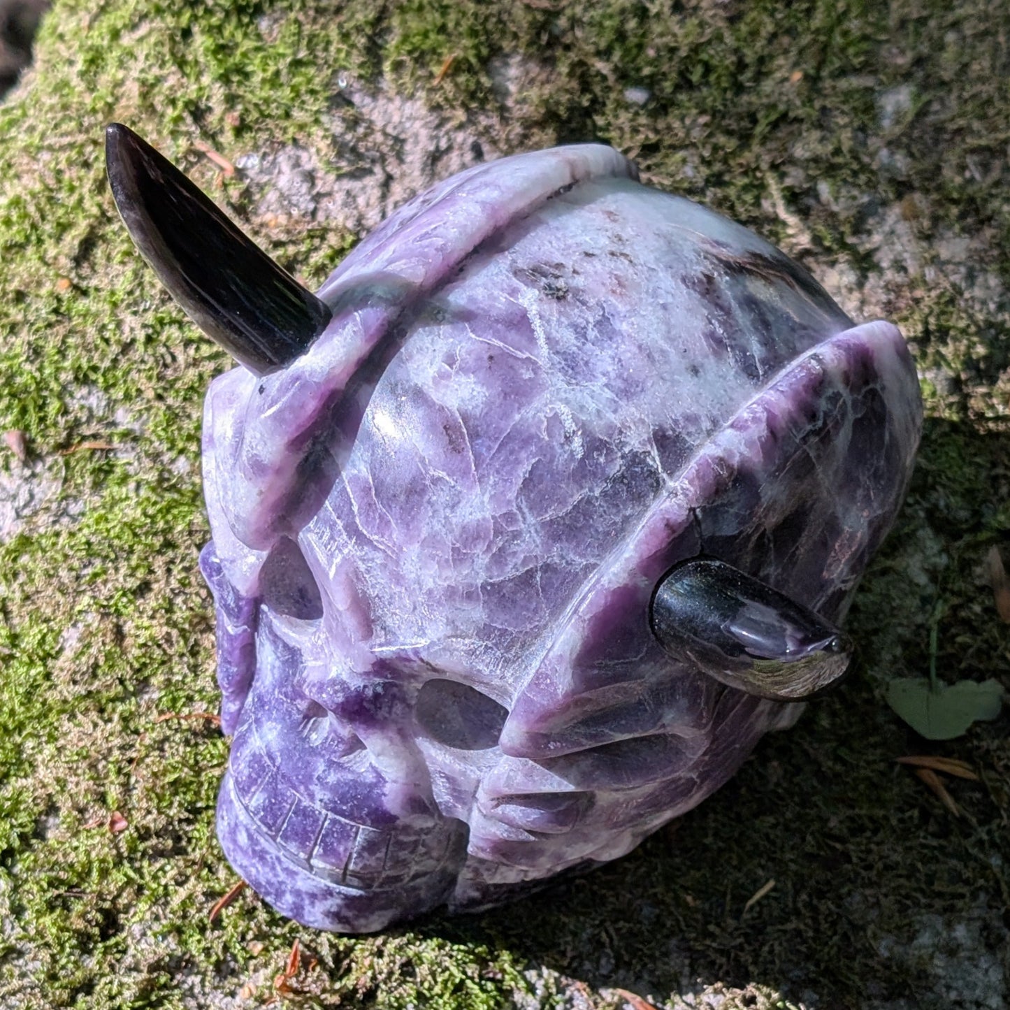 Kristallschädel "Schattenfürst" aus Amethyst mit schwarzen Obsidian-Hörnern.