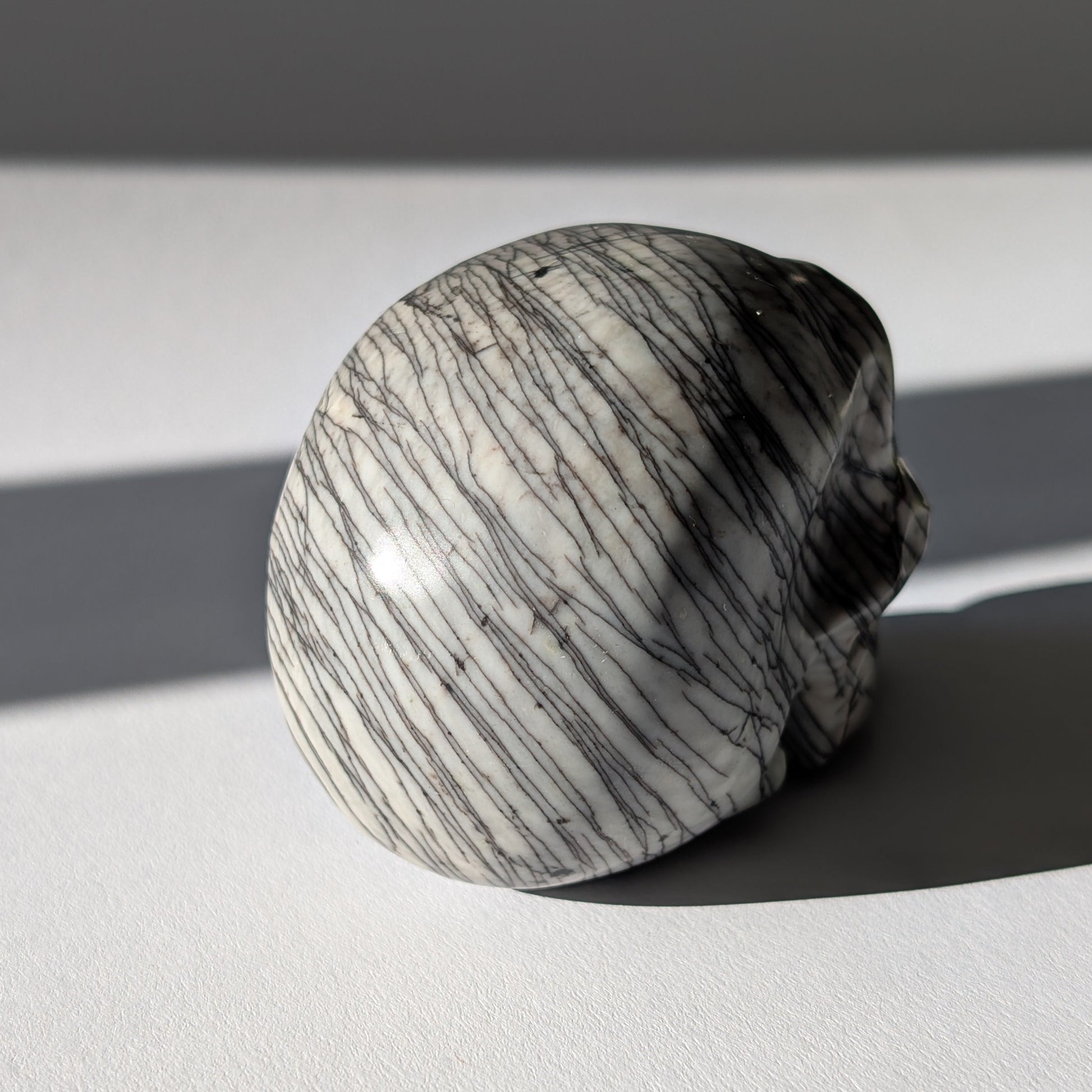 Kristallschädel "Townguard" (360g) aus Kalkstein mit markanter schwarz-weißer Zebra-Musterung.