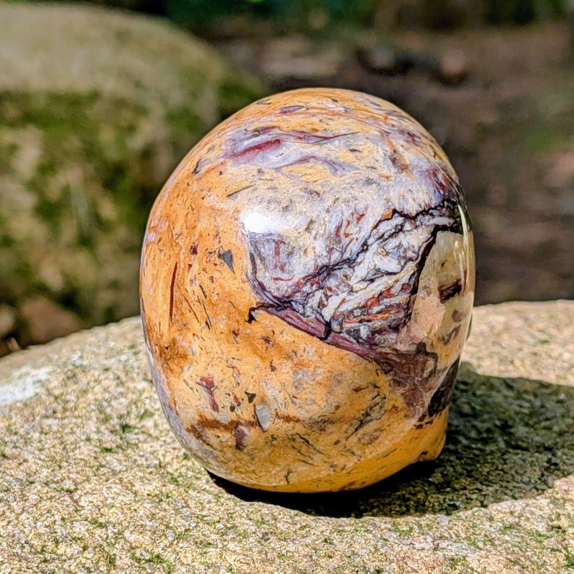 Kristallschädel "Wüstenwächter" aus Polychrom-Jaspis mit rötlicher und gelber Maserung.