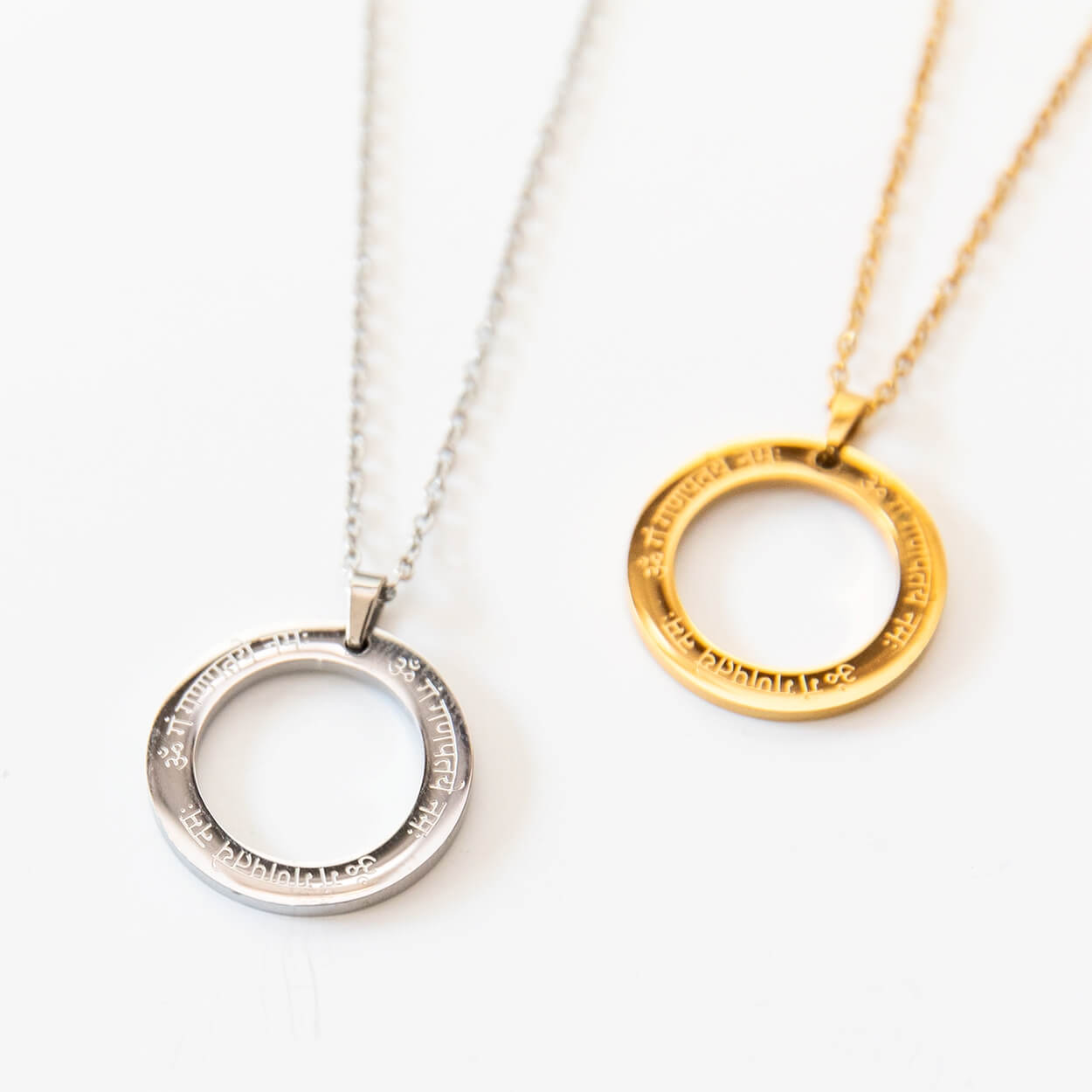 Silberfarbene Mantra Kette mit Ganesha-Gravur auf hellem Untergrund