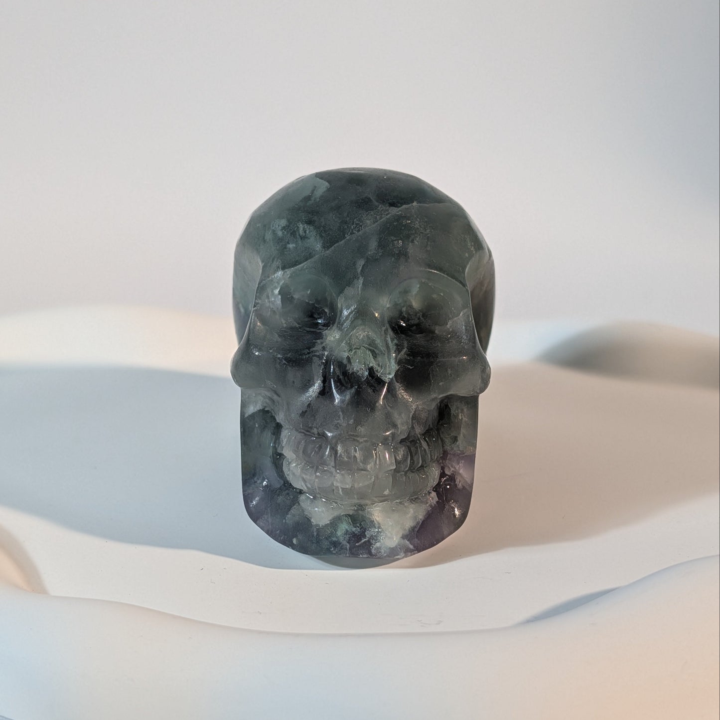 Massiver Kristallschädel Brigor aus dunklem Fluorit mit tiefgrünen und abgründigen, violetten Farbzonen.