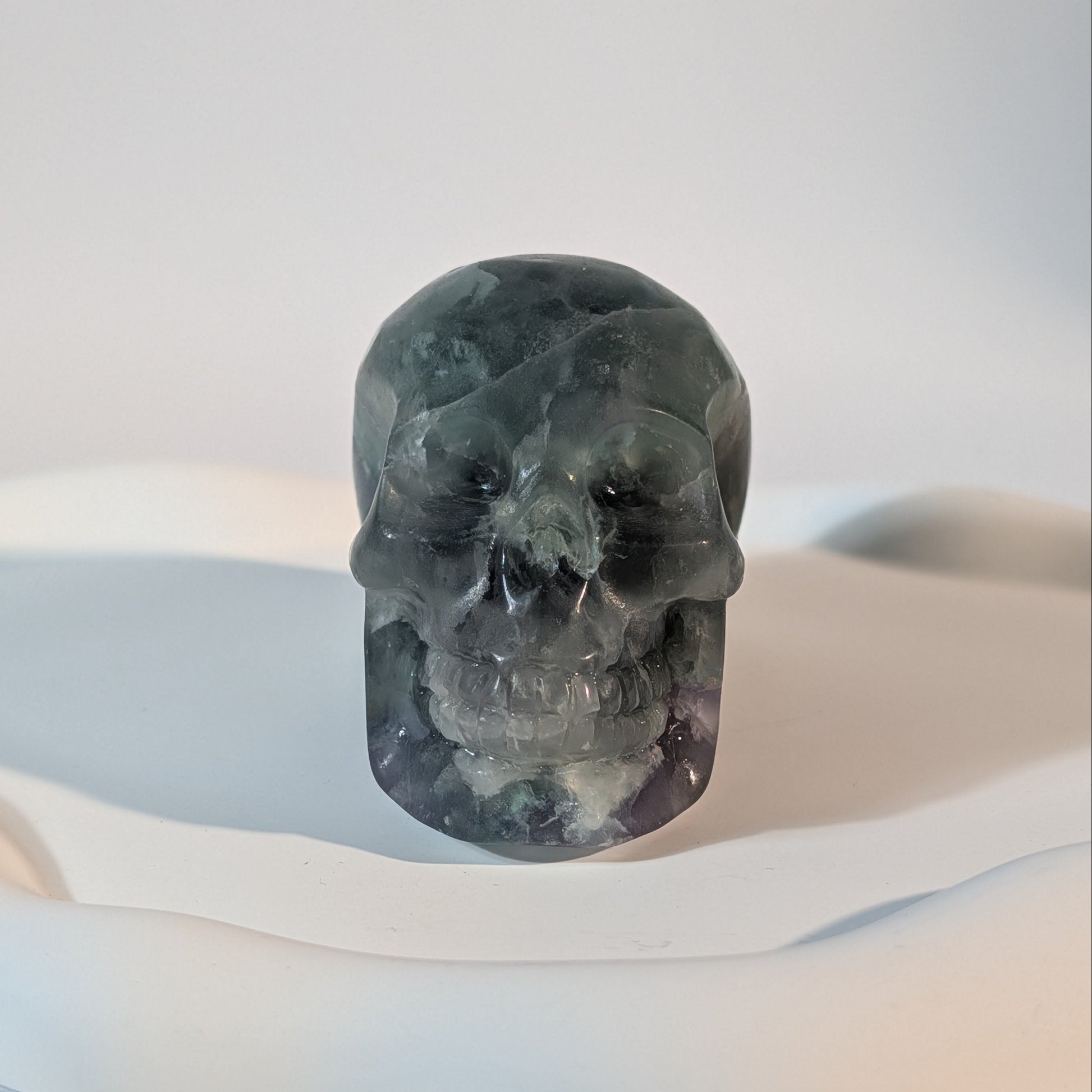 Massiver Kristallschädel Brigor aus dunklem Fluorit mit tiefgrünen und abgründigen, violetten Farbzonen.