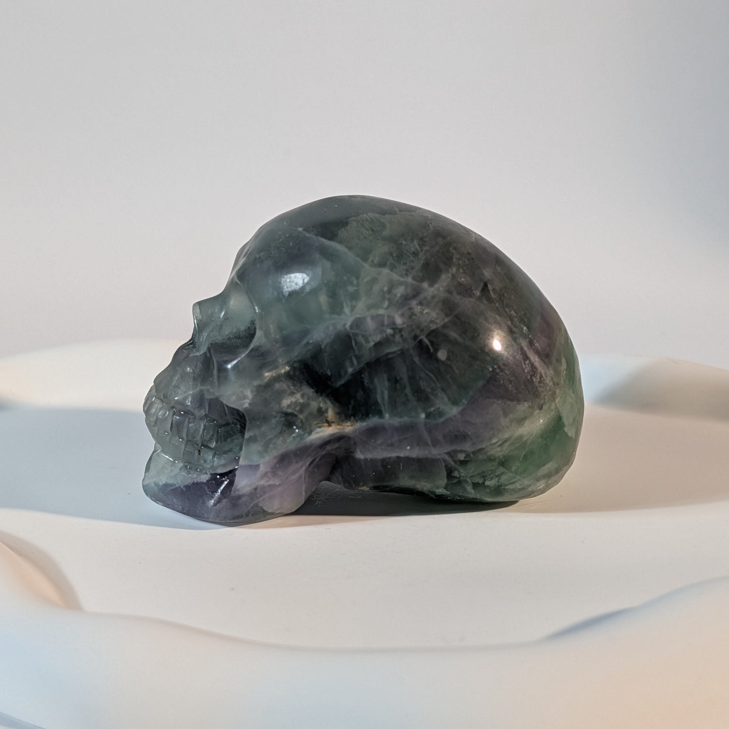 Massiver Kristallschädel Brigor aus dunklem Fluorit mit tiefgrünen und abgründigen, violetten Farbzonen.
