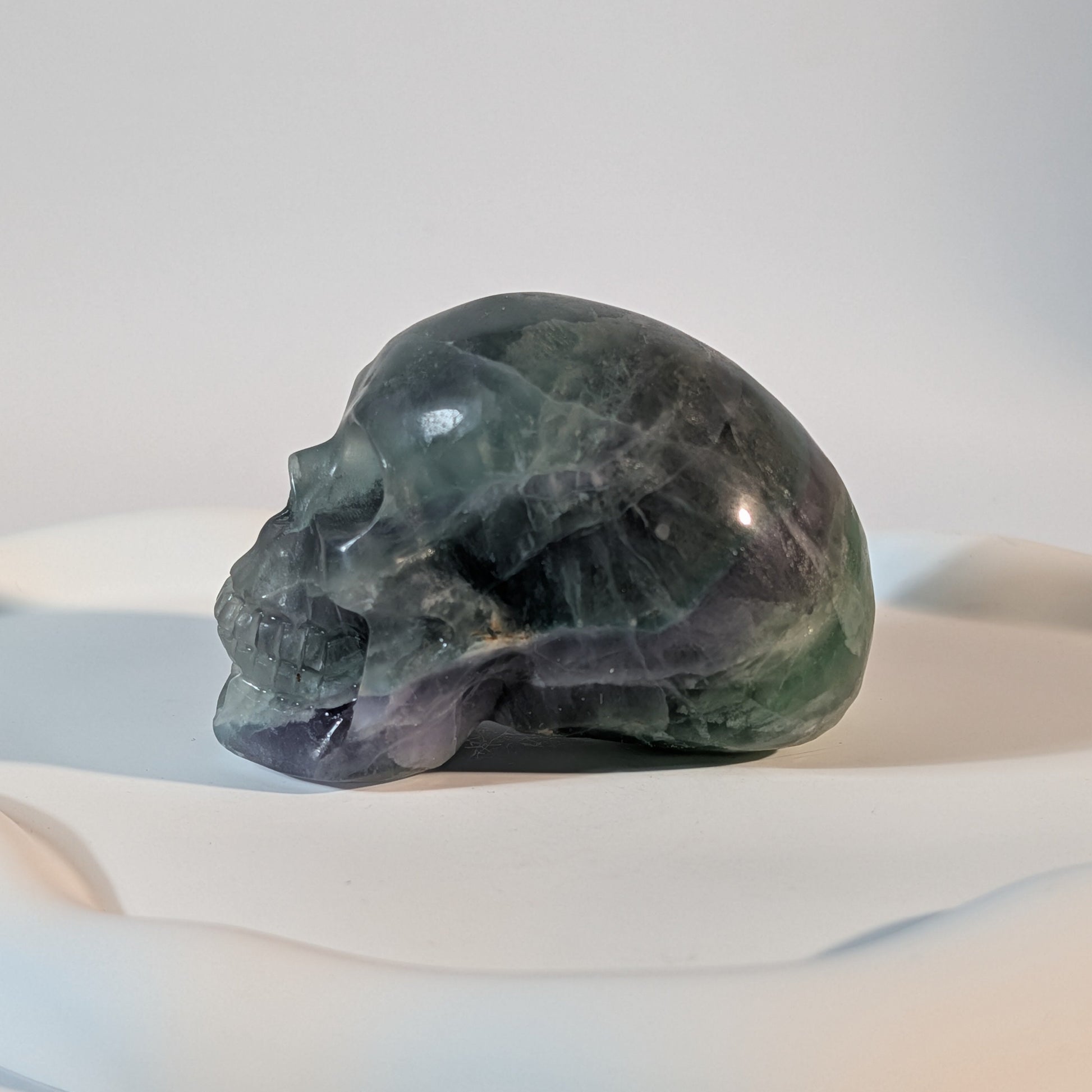 Massiver Kristallschädel Brigor aus dunklem Fluorit mit tiefgrünen und abgründigen, violetten Farbzonen.