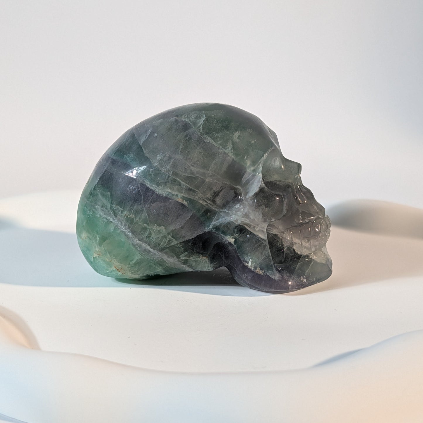 Massiver Kristallschädel Brigor aus dunklem Fluorit mit tiefgrünen und abgründigen, violetten Farbzonen.