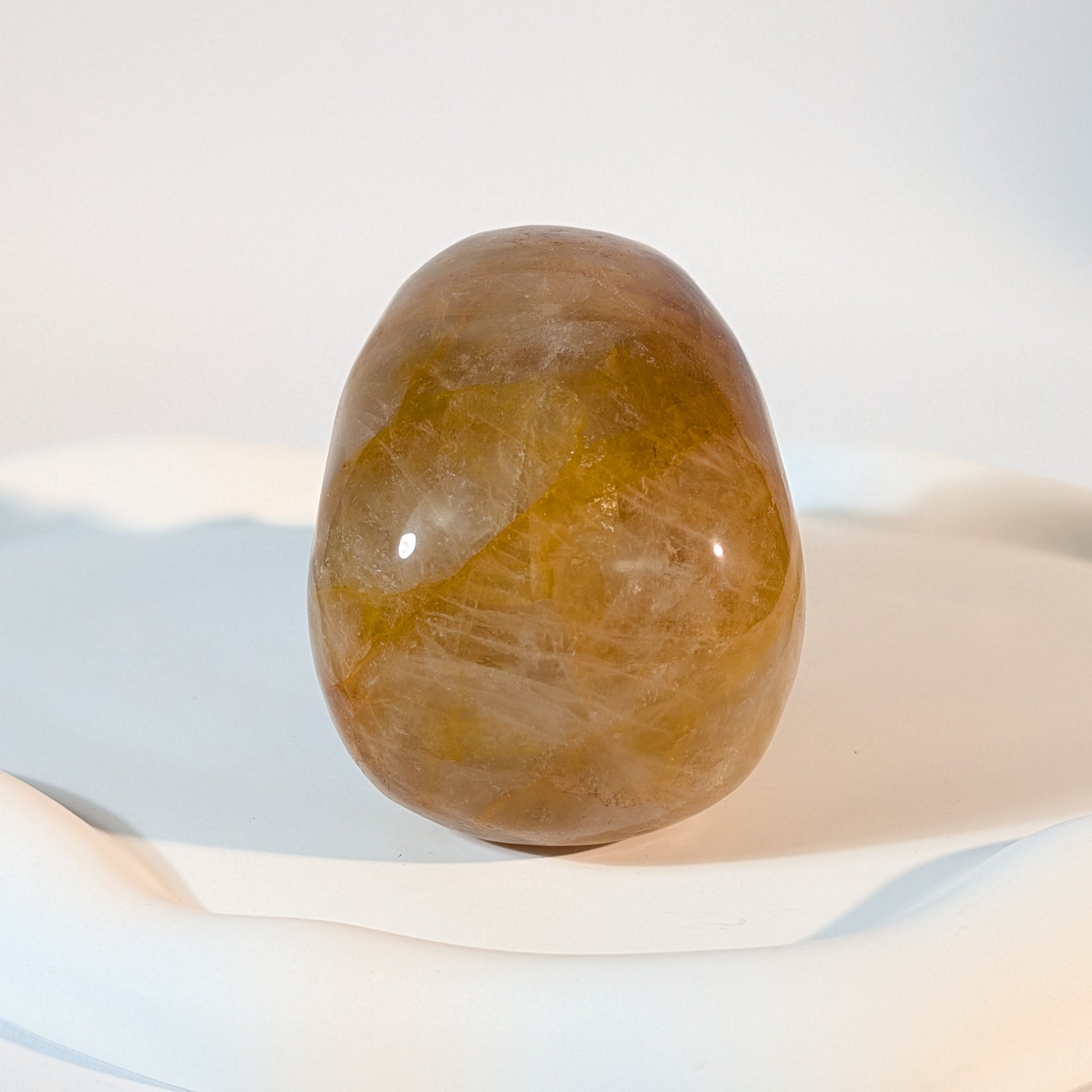 Massiver, bernsteinfarbener Kristallschädel Muirne aus Quarz mit tiefen, dunklen Rissen und rostigen Eiseneinschlüssen.