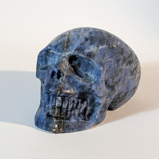 Mittelgroßer Kristallschädel Iawar aus tiefblauem Sodalith, 418 Gramm schwer, durchzogen mit natürlichen Calcit-Einschlüssen für Intuition und Klarheit.