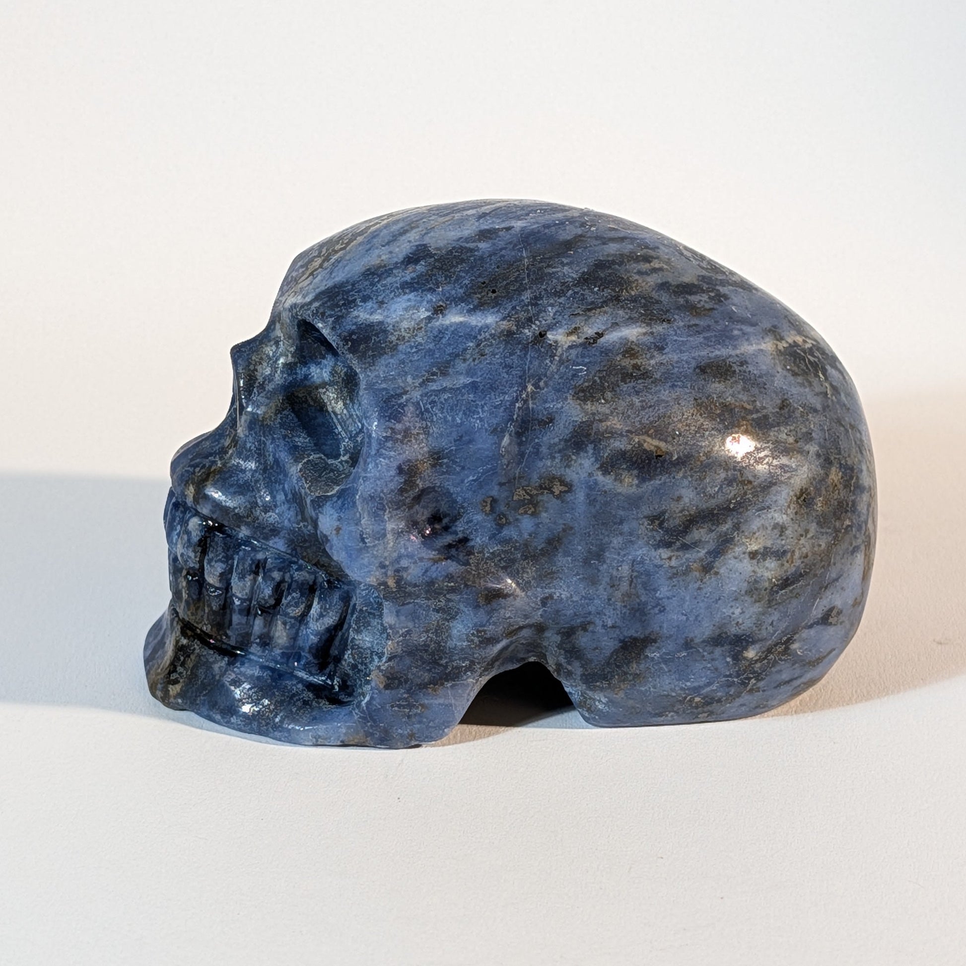Mittelgroßer Kristallschädel Iawar aus tiefblauem Sodalith, 418 Gramm schwer, durchzogen mit natürlichen Calcit-Einschlüssen für Intuition und Klarheit.