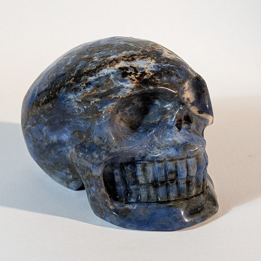 Mittelgroßer Kristallschädel Ivor aus blauem Sodalith mit weißen Adern, 521 Gramm schwer, für Intuition, Wahrheit und Klarheit.