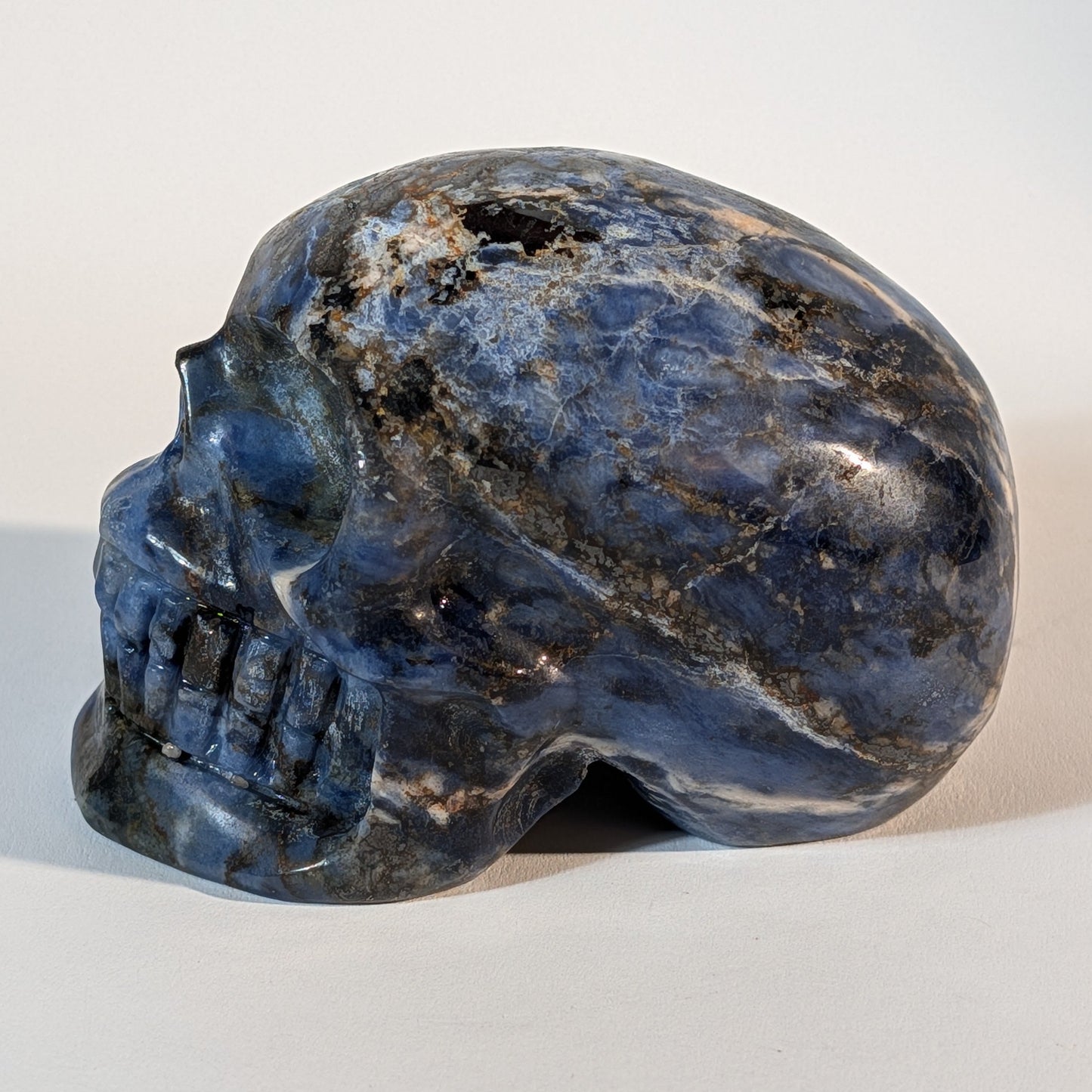 Mittelgroßer Kristallschädel Ivor aus blauem Sodalith mit weißen Adern, 521 Gramm schwer, für Intuition, Wahrheit und Klarheit.