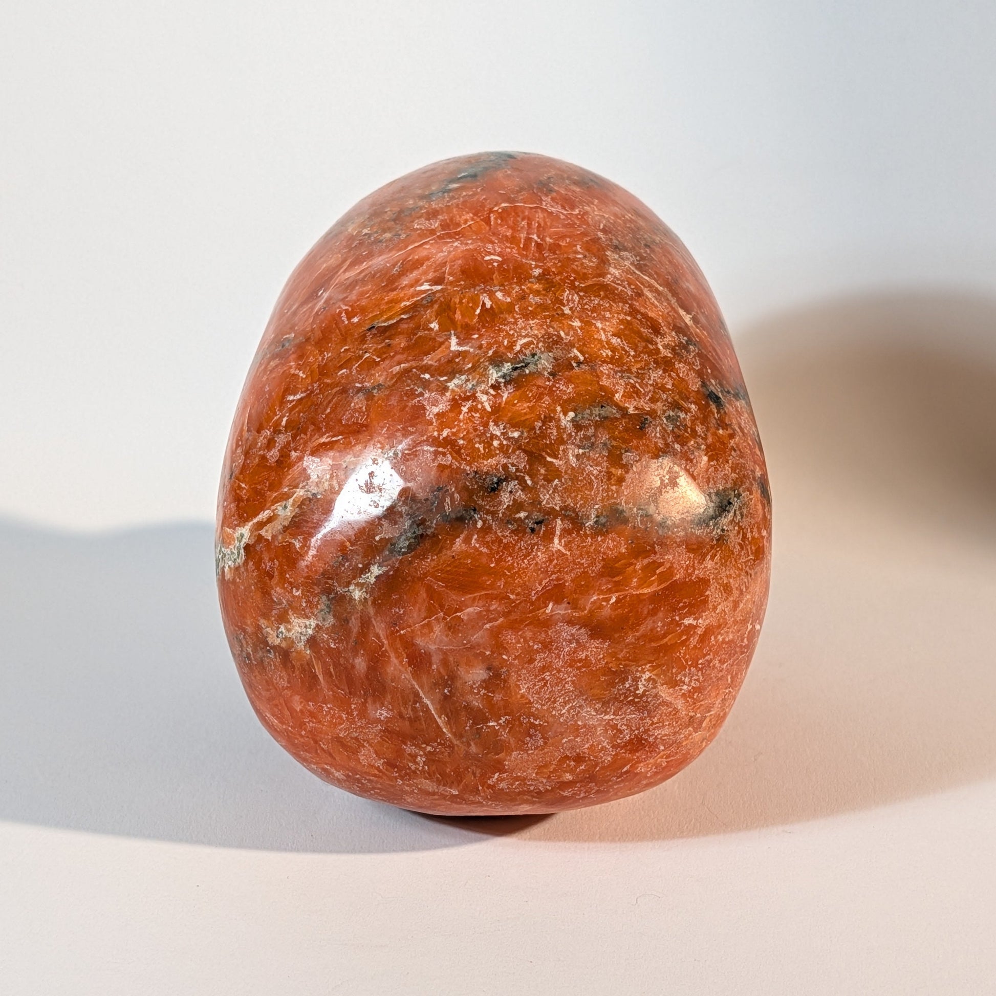 Mittelgroßer, handgeschnitzter Kristallschädel Istemo aus orange-rotem Sonnenstein (Oligoklas), 935 Gramm schwer, für Lebensfreude und Optimismus.