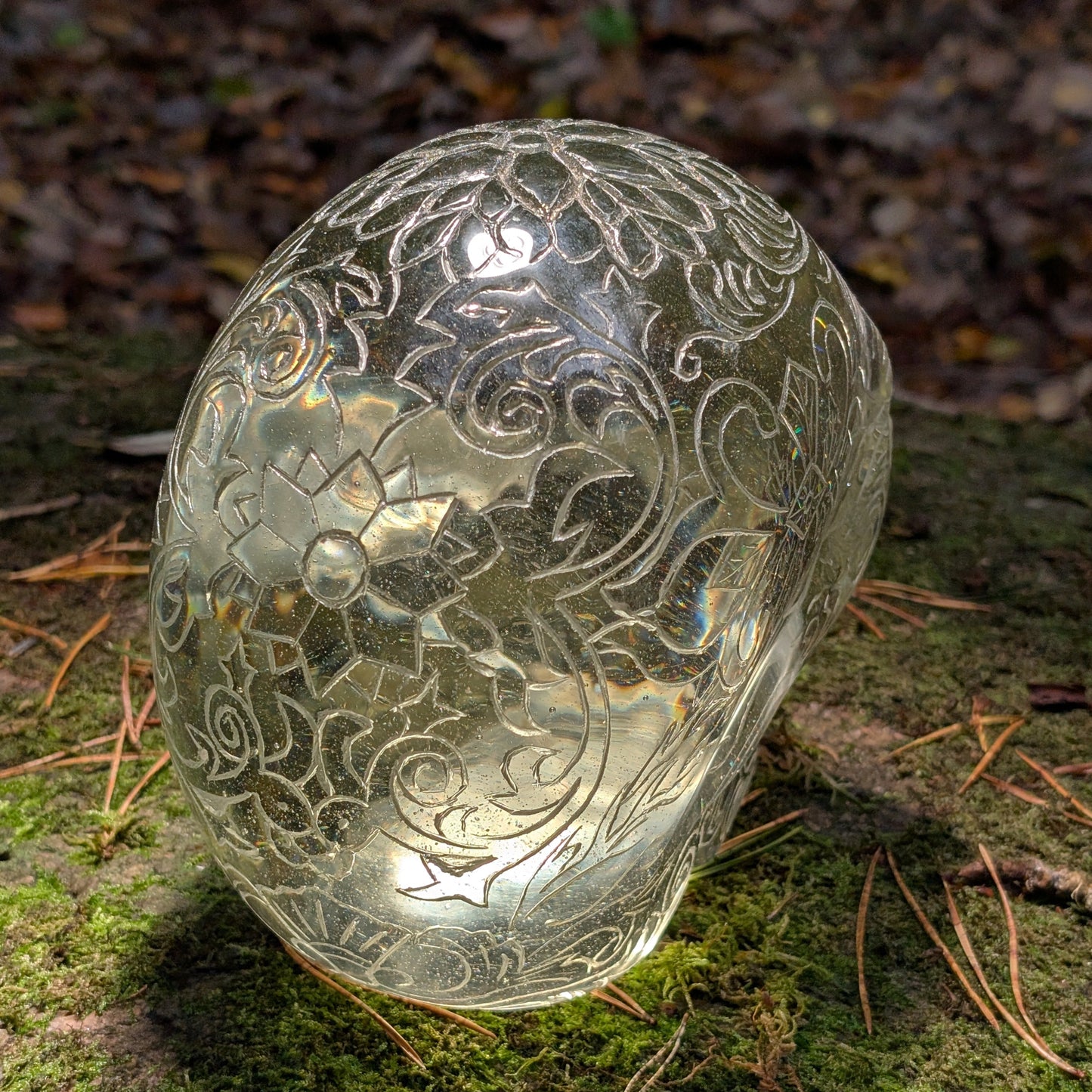 Monumentaler 6.4kg Kristallschädel "Hekate" aus gelbem Obsidian mit vollflächiger Handgravur, auf Moos im Wald liegend.