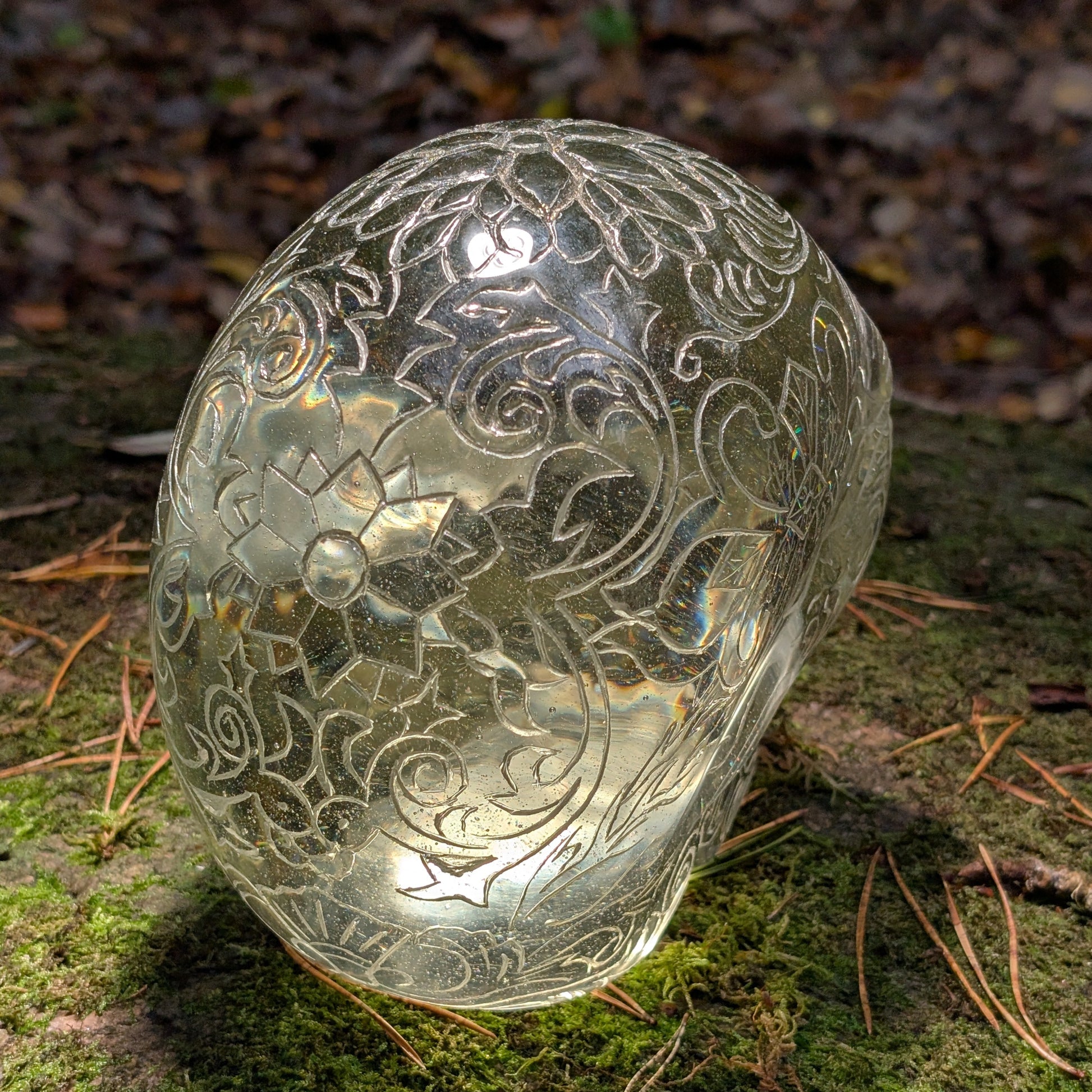 Monumentaler 6.4kg Kristallschädel "Hekate" aus gelbem Obsidian mit vollflächiger Handgravur, auf Moos im Wald liegend.