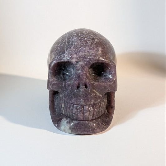 Monumentaler, handgeschnitzter Kristallschädel Corey aus violettem Lepidolith (Mischkristall-Matrix), 1810 Gramm schwer, mit weißen Einschlüssen für Stressabbau.