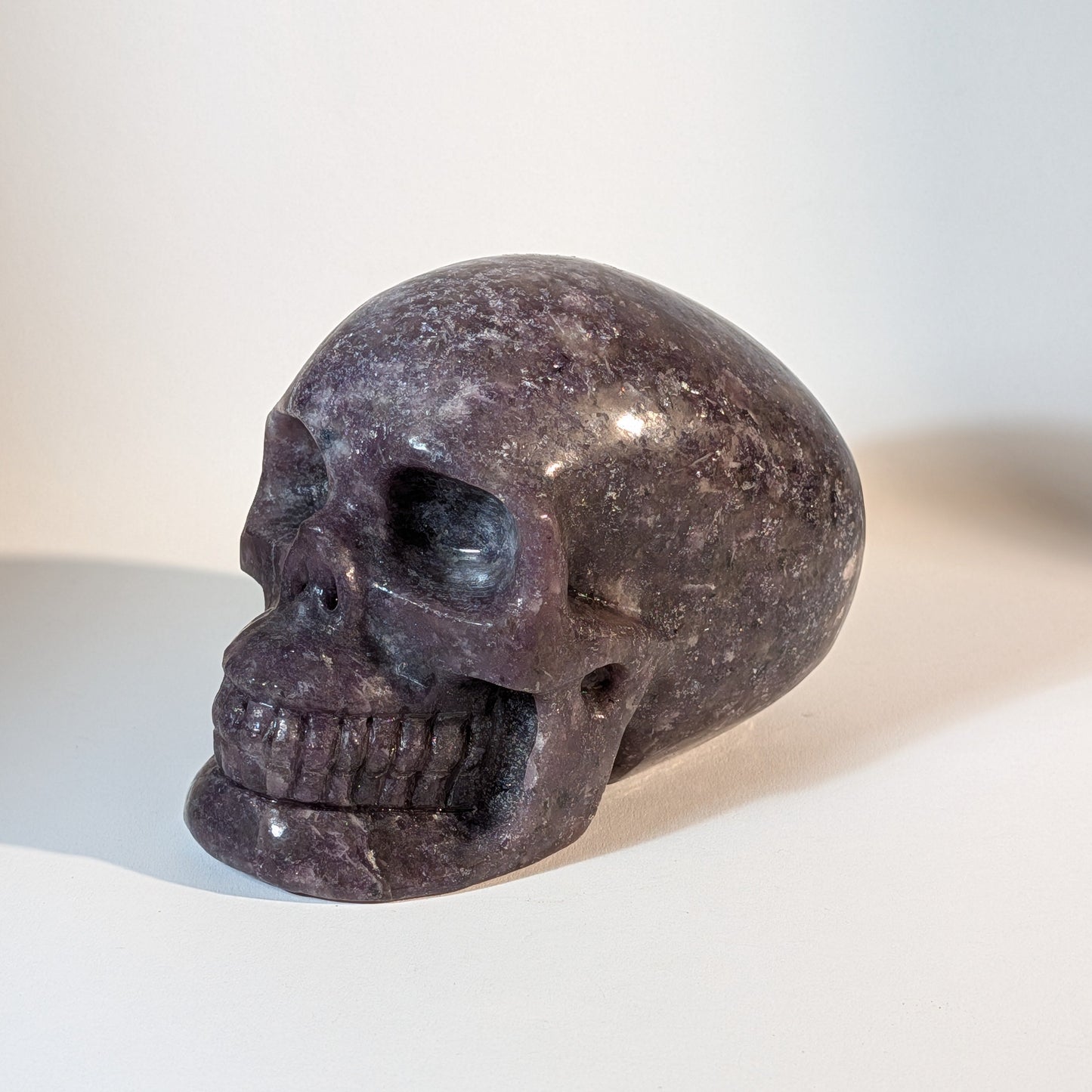 Monumentaler, handgeschnitzter Kristallschädel Corey aus violettem Lepidolith (Mischkristall-Matrix), 1810 Gramm schwer, mit weißen Einschlüssen für Stressabbau.