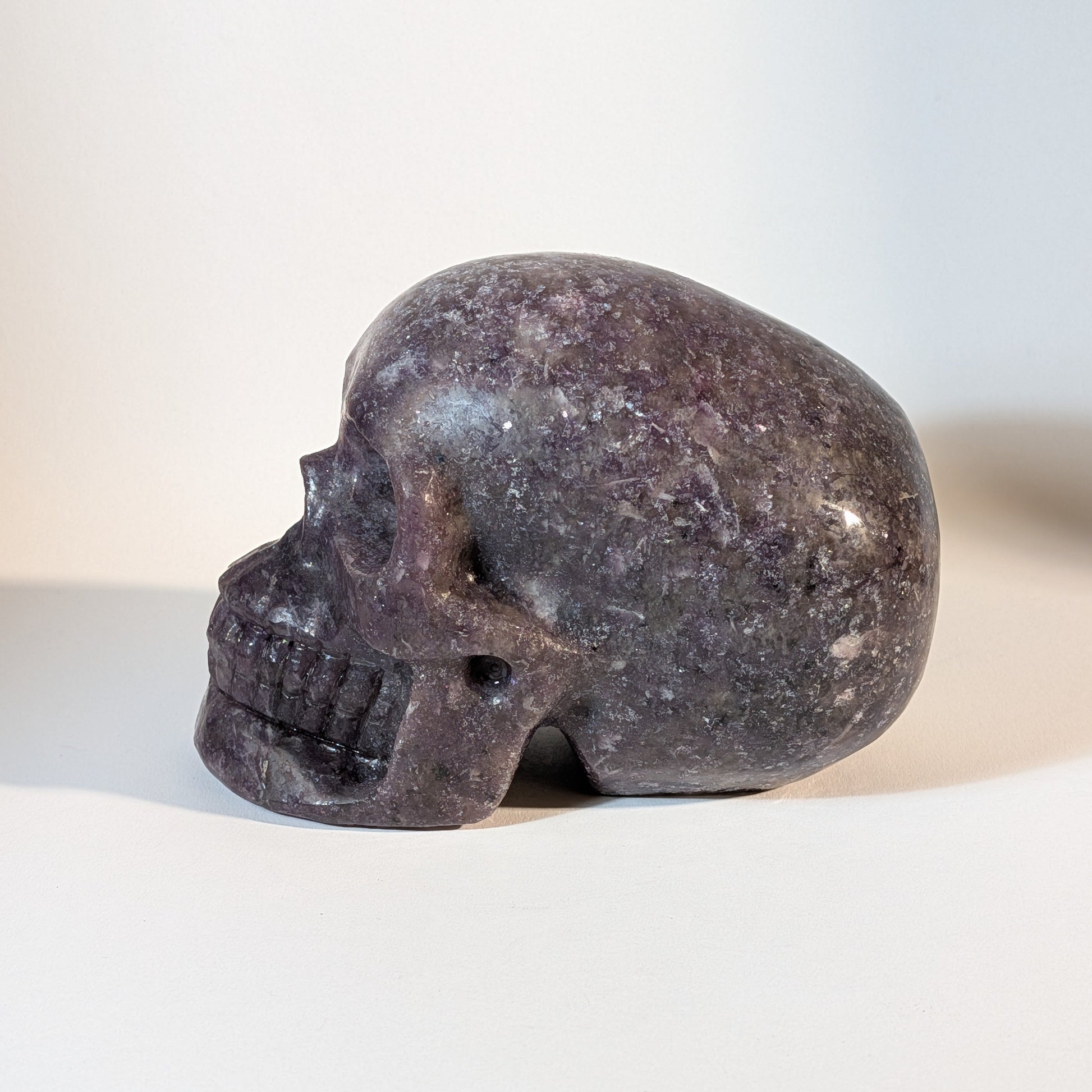 Monumentaler, handgeschnitzter Kristallschädel Corey aus violettem Lepidolith (Mischkristall-Matrix), 1810 Gramm schwer, mit weißen Einschlüssen für Stressabbau.