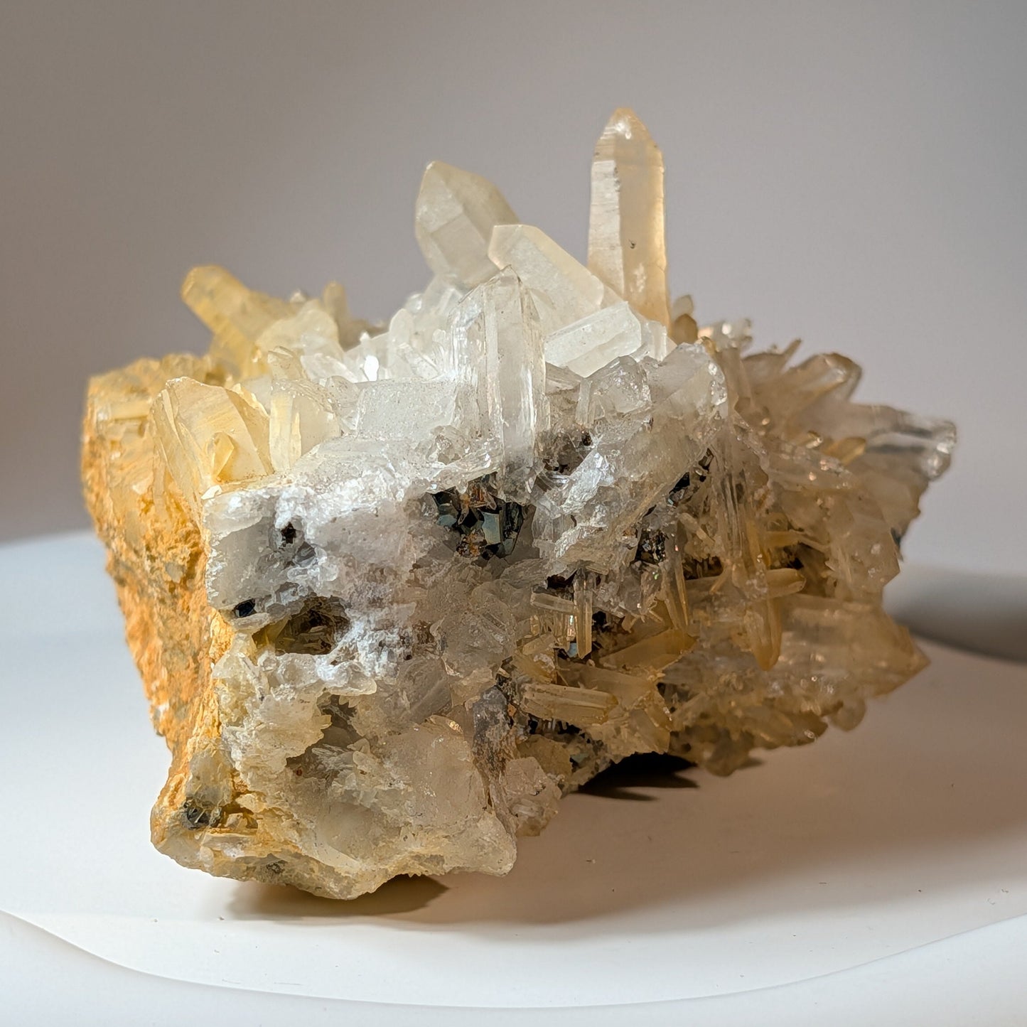 Naturbelassene Mineralienstufe aus klaren Bergkristall-Spitzen mit goldenen Pyrit-Einschlüssen, 442 Gramm schwer. Kraftvoller Heilstein für Manifestation.
