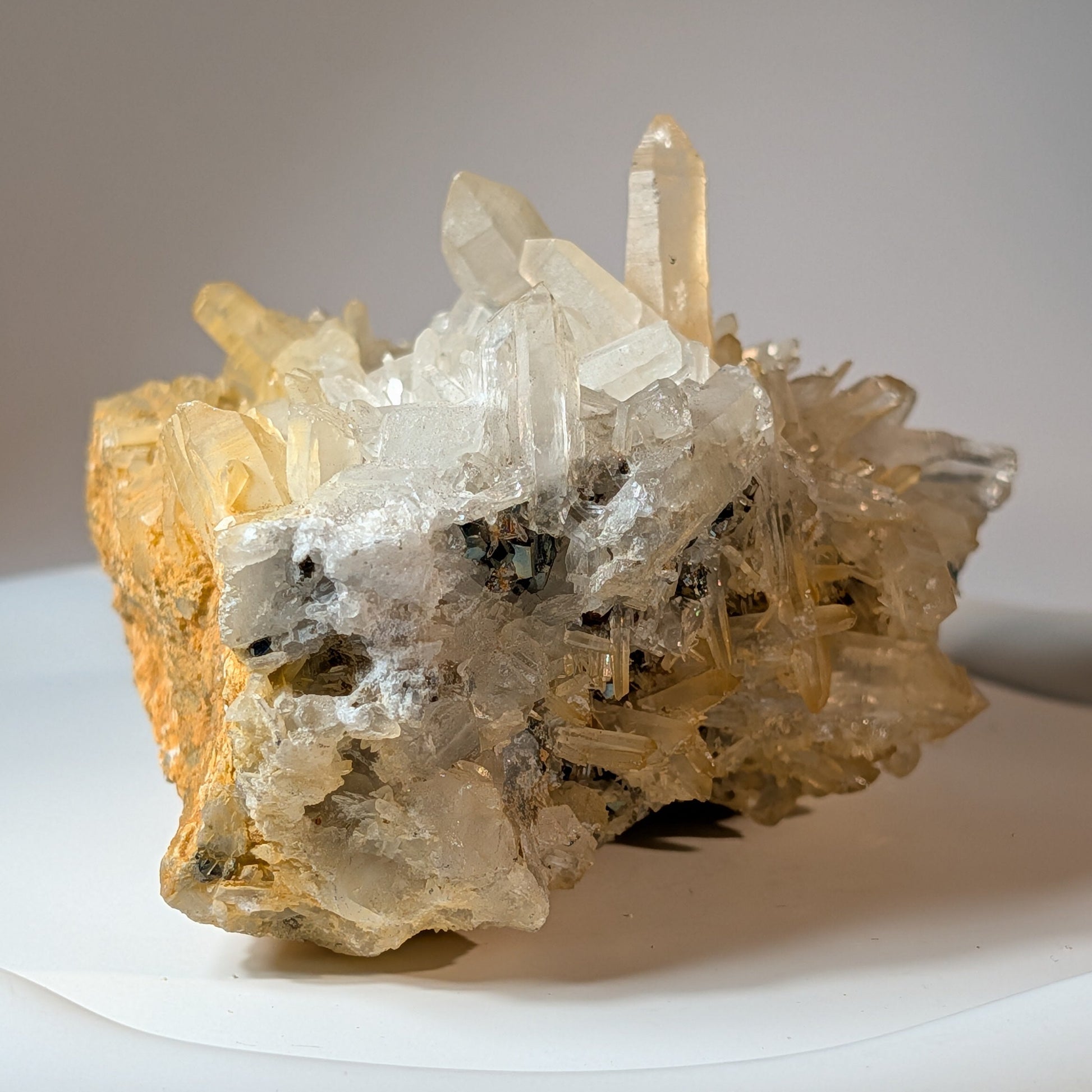 Naturbelassene Mineralienstufe aus klaren Bergkristall-Spitzen mit goldenen Pyrit-Einschlüssen, 442 Gramm schwer. Kraftvoller Heilstein für Manifestation.
