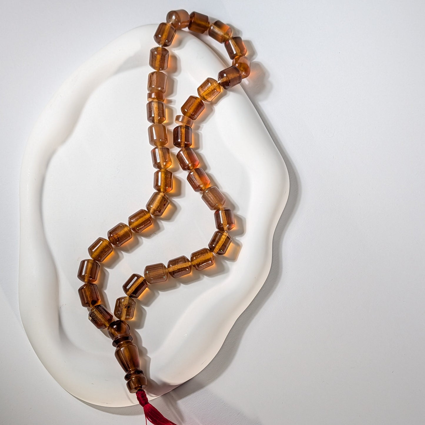 Exklusive, handgefertigte Gebetskette (Mala/Tasbih) aus honigfarbenem Bernstein in Walzenform mit roter Quaste, 50g für Meditation und Schutz - Temple of Desire