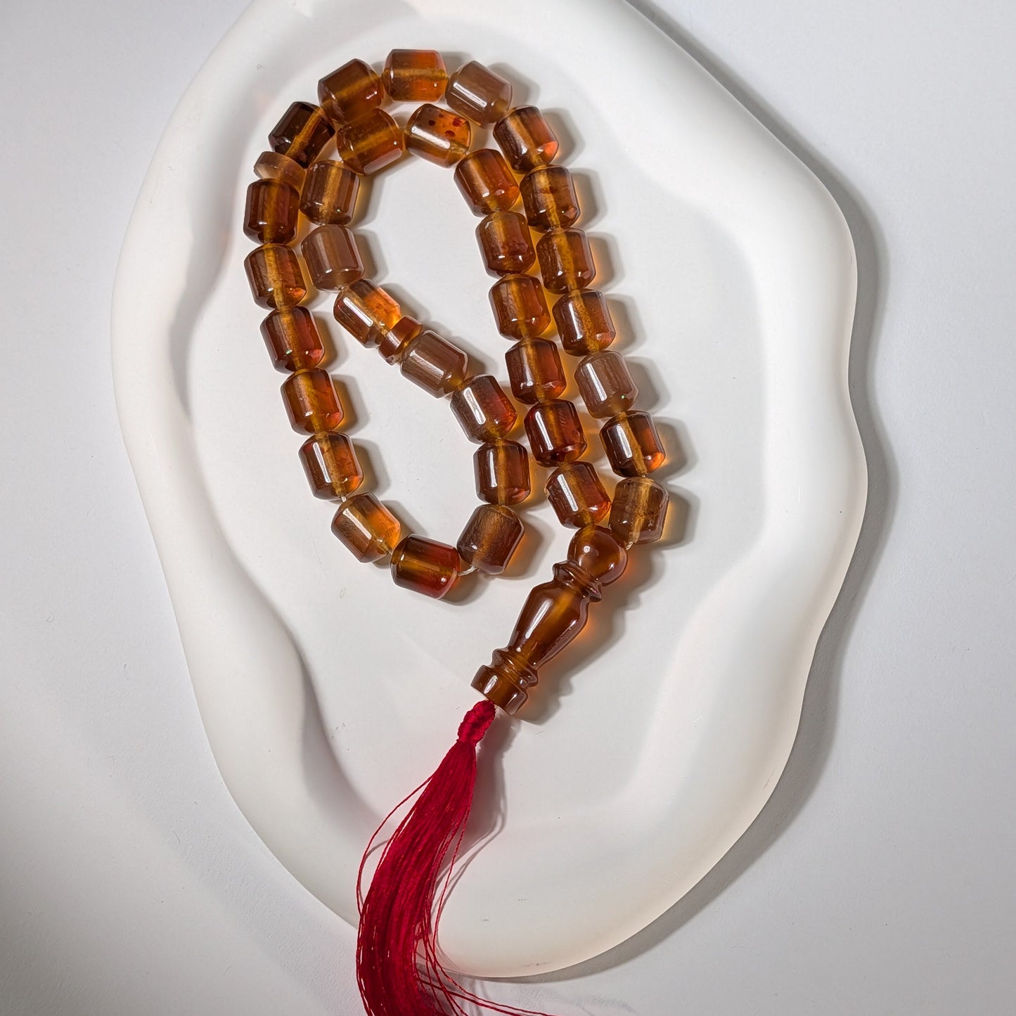 Exklusive, handgefertigte Gebetskette (Mala/Tasbih) aus honigfarbenem Bernstein in Walzenform mit roter Quaste, 50g für Meditation und Schutz - Temple of Desire