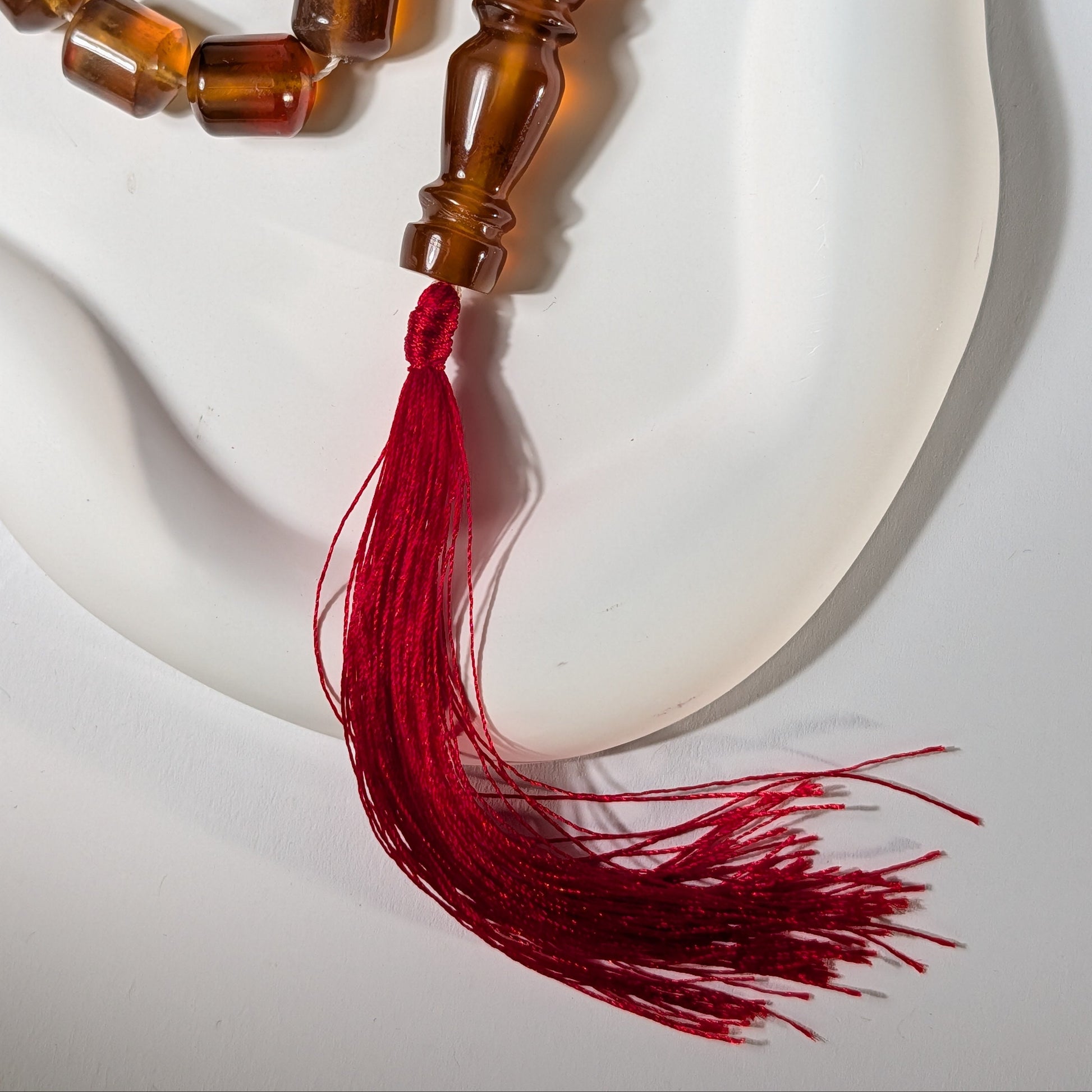 Exklusive, handgefertigte Gebetskette (Mala/Tasbih) aus honigfarbenem Bernstein in Walzenform mit roter Quaste, 50g für Meditation und Schutz - Temple of Desire