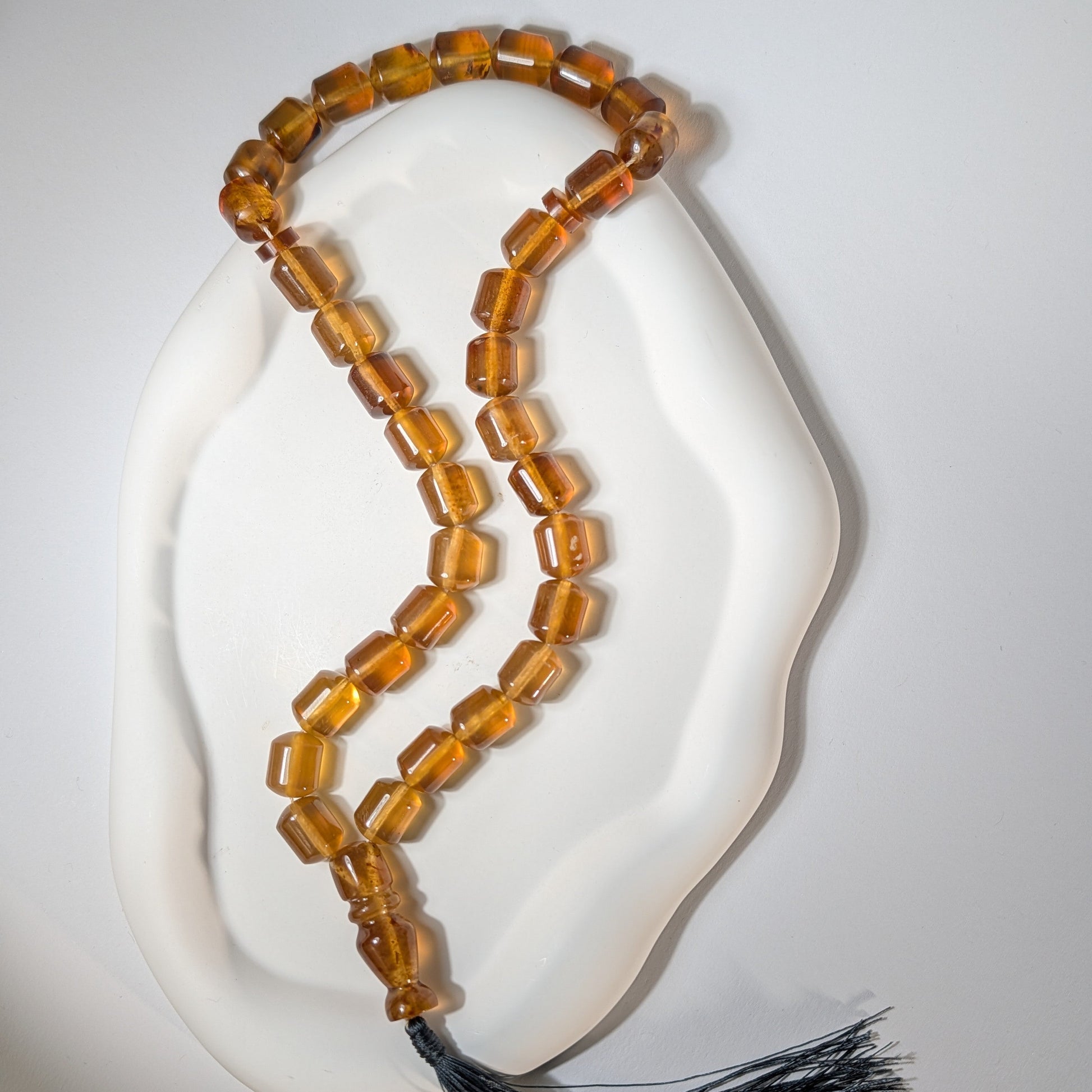Handgefertigte Gebetskette (Mala/Tasbih) aus honigfarbenem Bernstein in Walzenform mit tiefgrüner Quaste, 50g für Herzheilung und Meditation - Temple of Desire