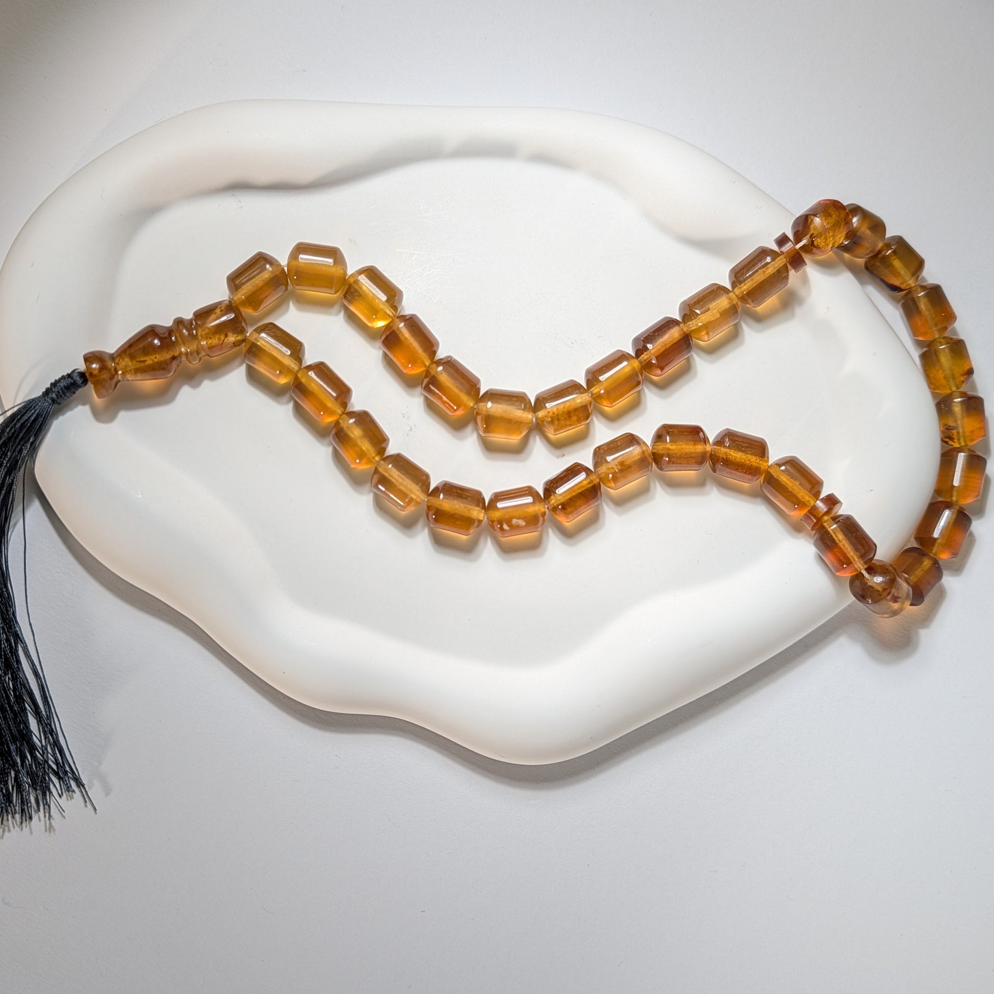 Handgefertigte Gebetskette (Mala/Tasbih) aus honigfarbenem Bernstein in Walzenform mit tiefgrüner Quaste, 50g für Herzheilung und Meditation - Temple of Desire