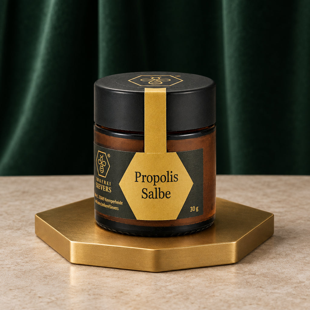 Propolis Salbe der Imkerei Sievers im dunklen Glastiegel mit goldenem Etikett auf goldenem Sockel