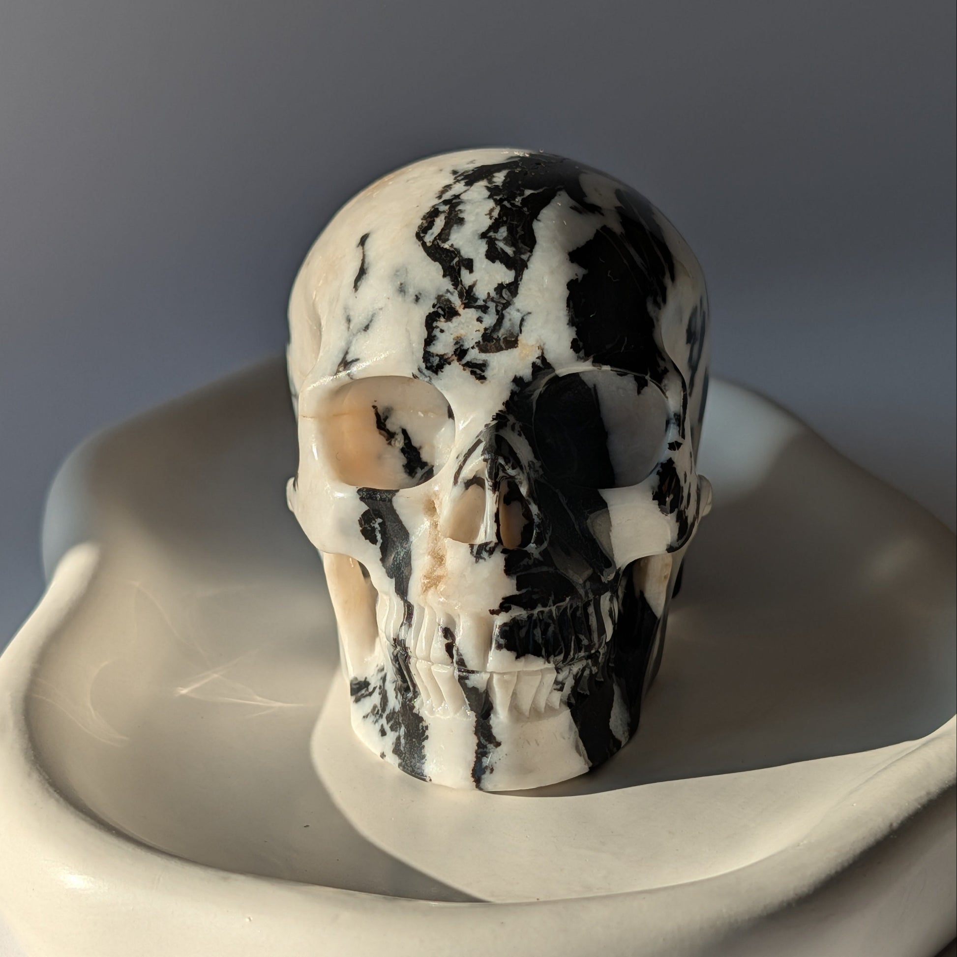 Schwarz-weißer Kristallschädel Gruolun Kalkstein 697g Zebra Muster