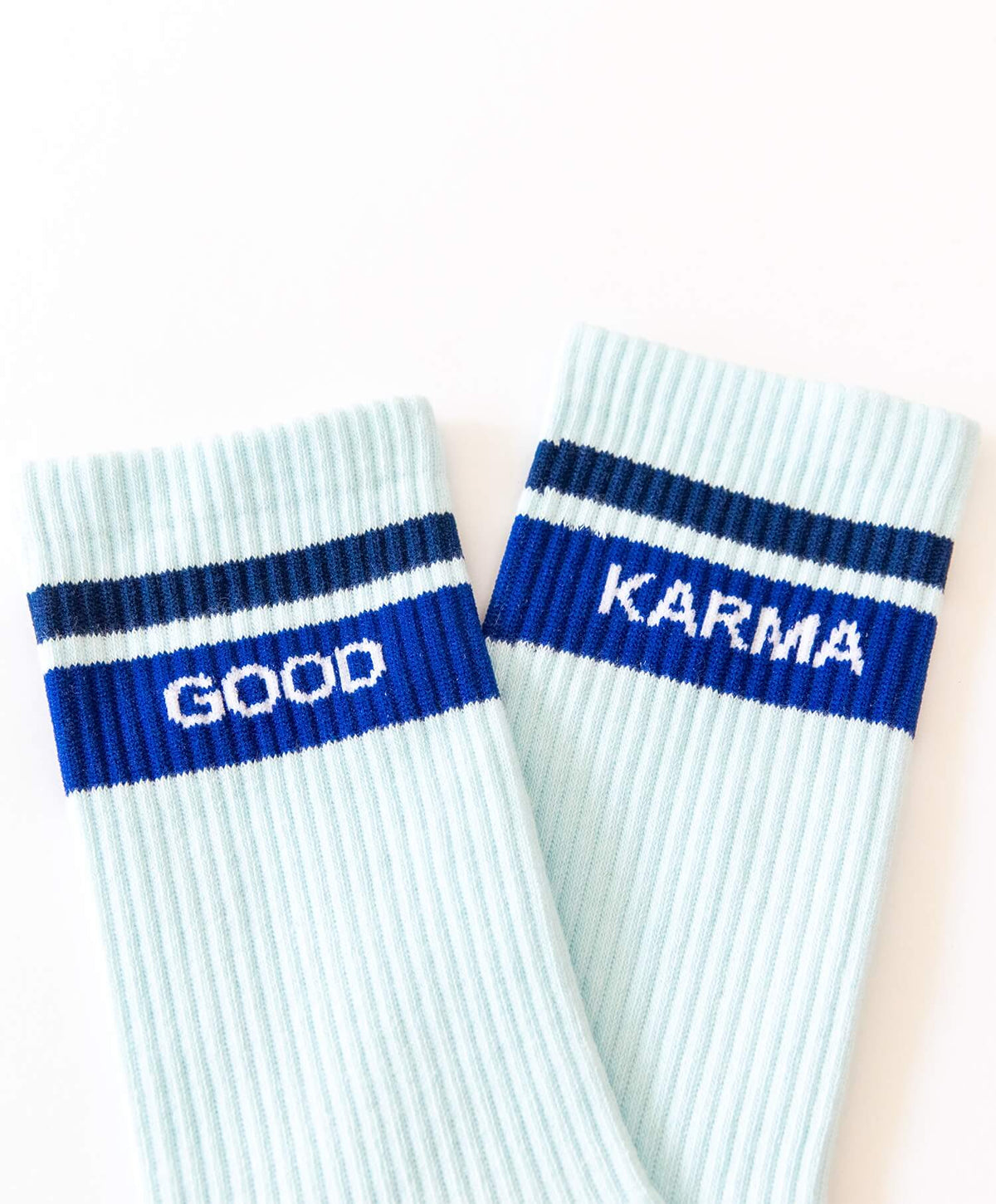 Zwei Good-Karma-Socken nebeneinander mit sichtbarem Schriftzug am Bund
