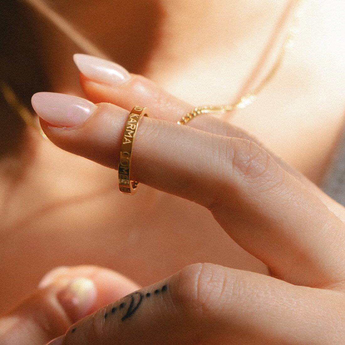 Ringkette getragen über schlichtem Oberteil, Ring auf Brusthöhe