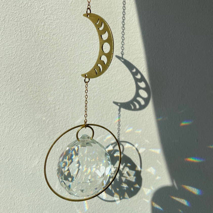 Suncatcher Mondphase aus Kristallglas und Messing, der Regenbogenlichter erzeugt.