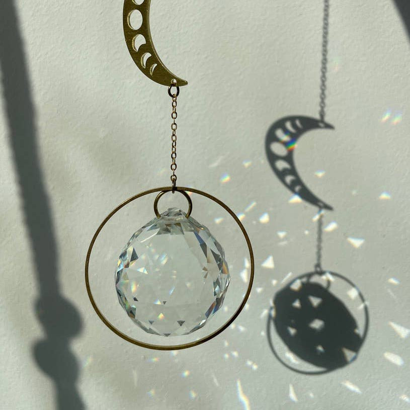 Suncatcher Mondphase aus Kristallglas und Messing, der Regenbogenlichter erzeugt.