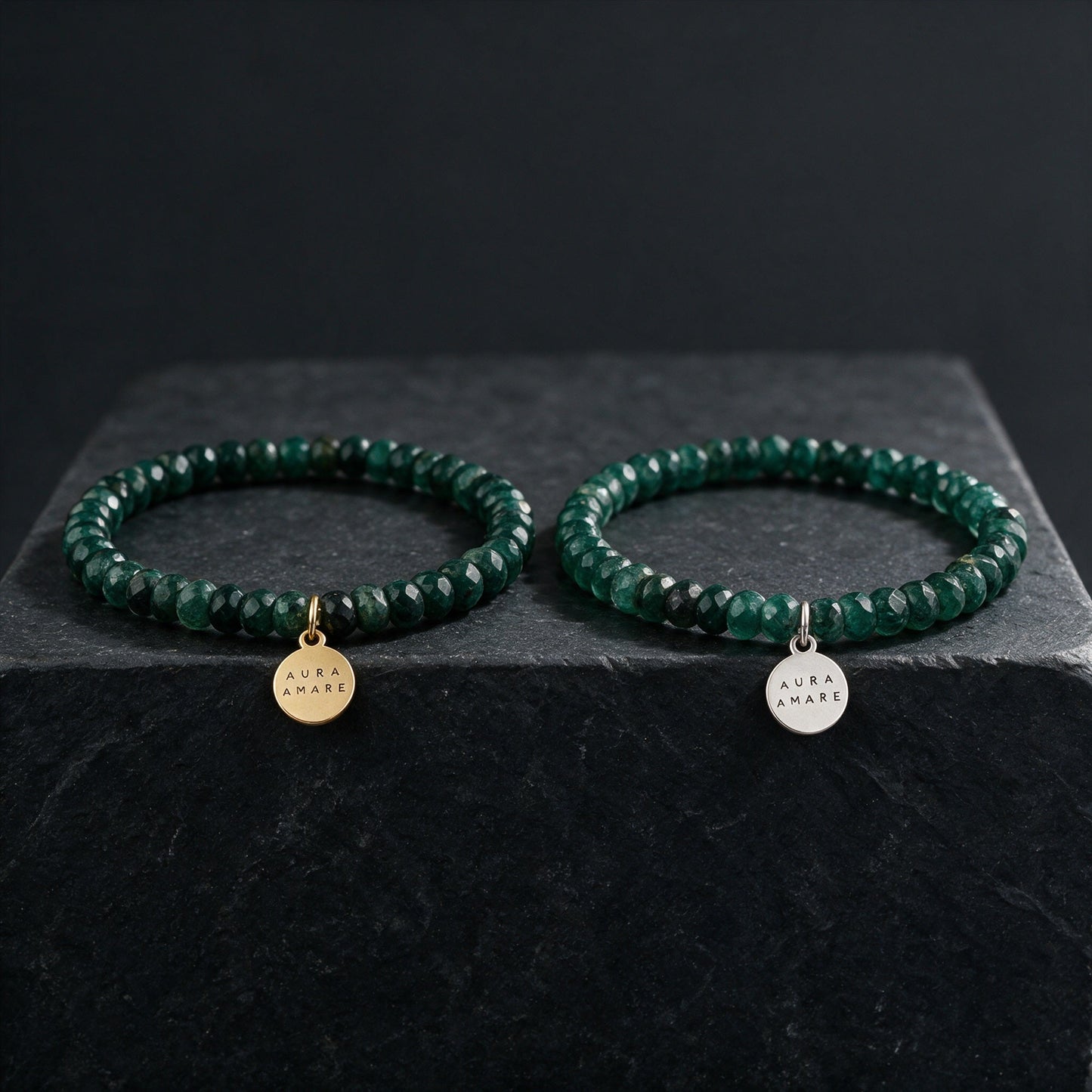 Aventurin Armband in Gold und Silber von AURA AMARE vor tiefem Smaragdgrün