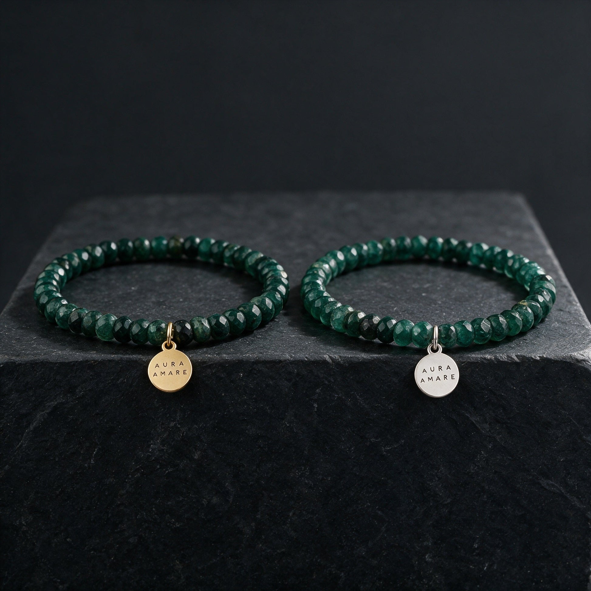 Aventurin Armband in Gold und Silber von AURA AMARE vor tiefem Smaragdgrün