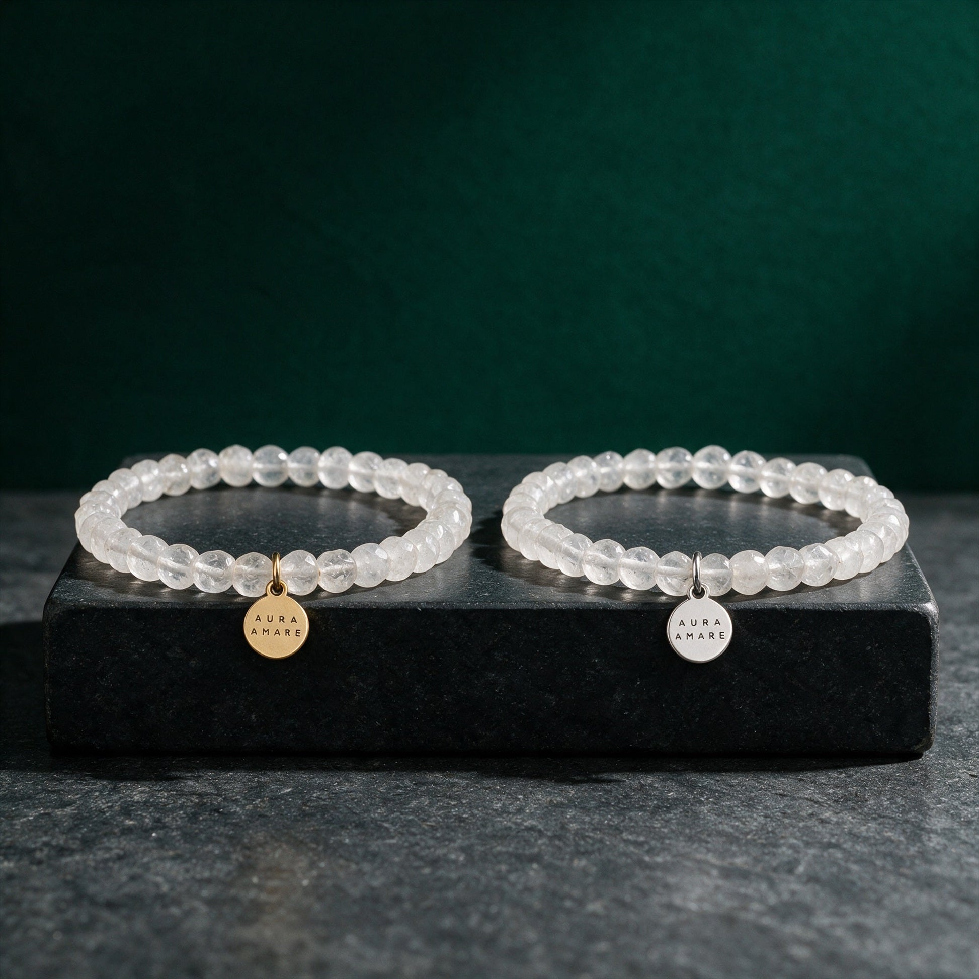 Bergkristall Armband in Gold und Silber von AURA AMARE vor tiefem Smaragdgrün