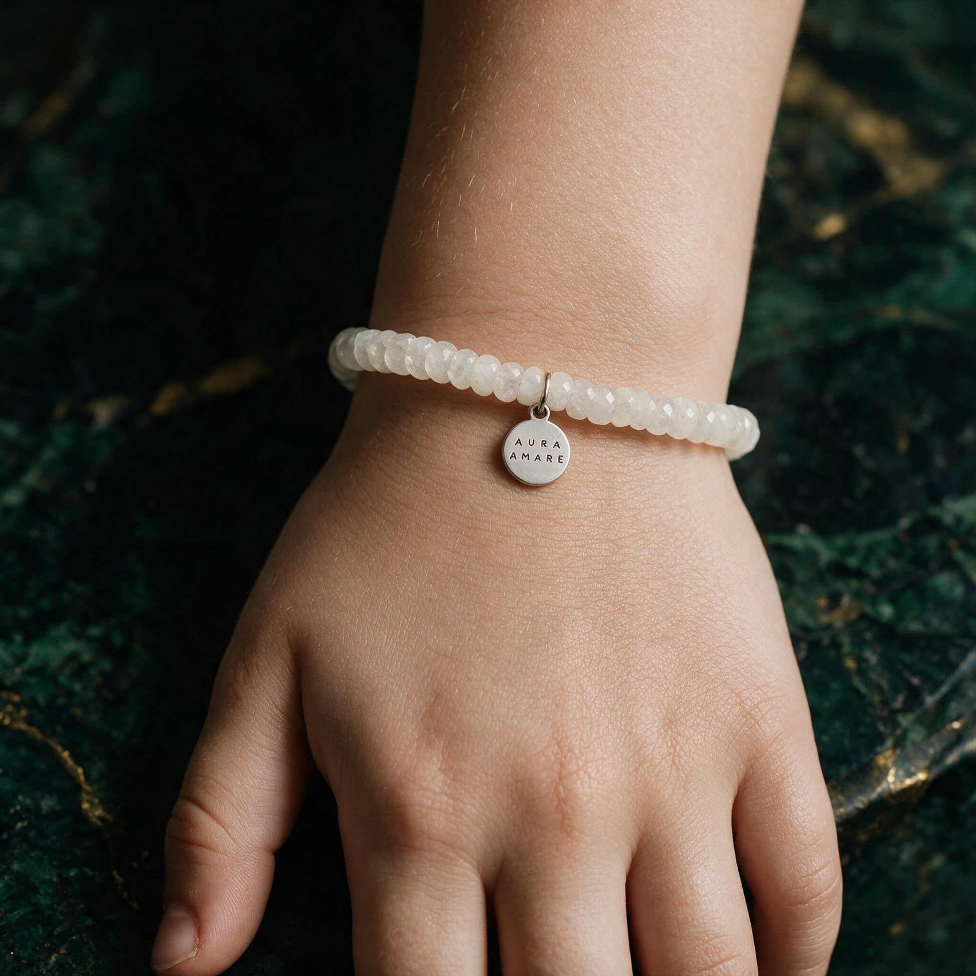 Kinder Regenbogen-Mondstein Armband in Silber am Handgelenk in einer eleganten Anwendungsszene