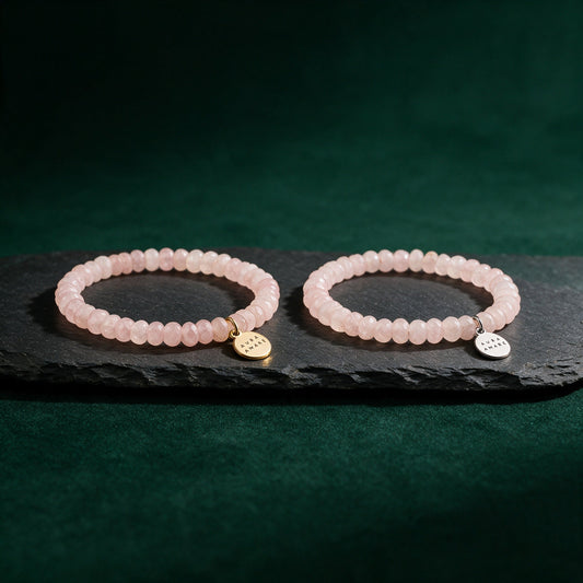 Kinder Rosenquarz Armband in Gold und Silber von AURA AMARE vor tiefem Smaragdgrün