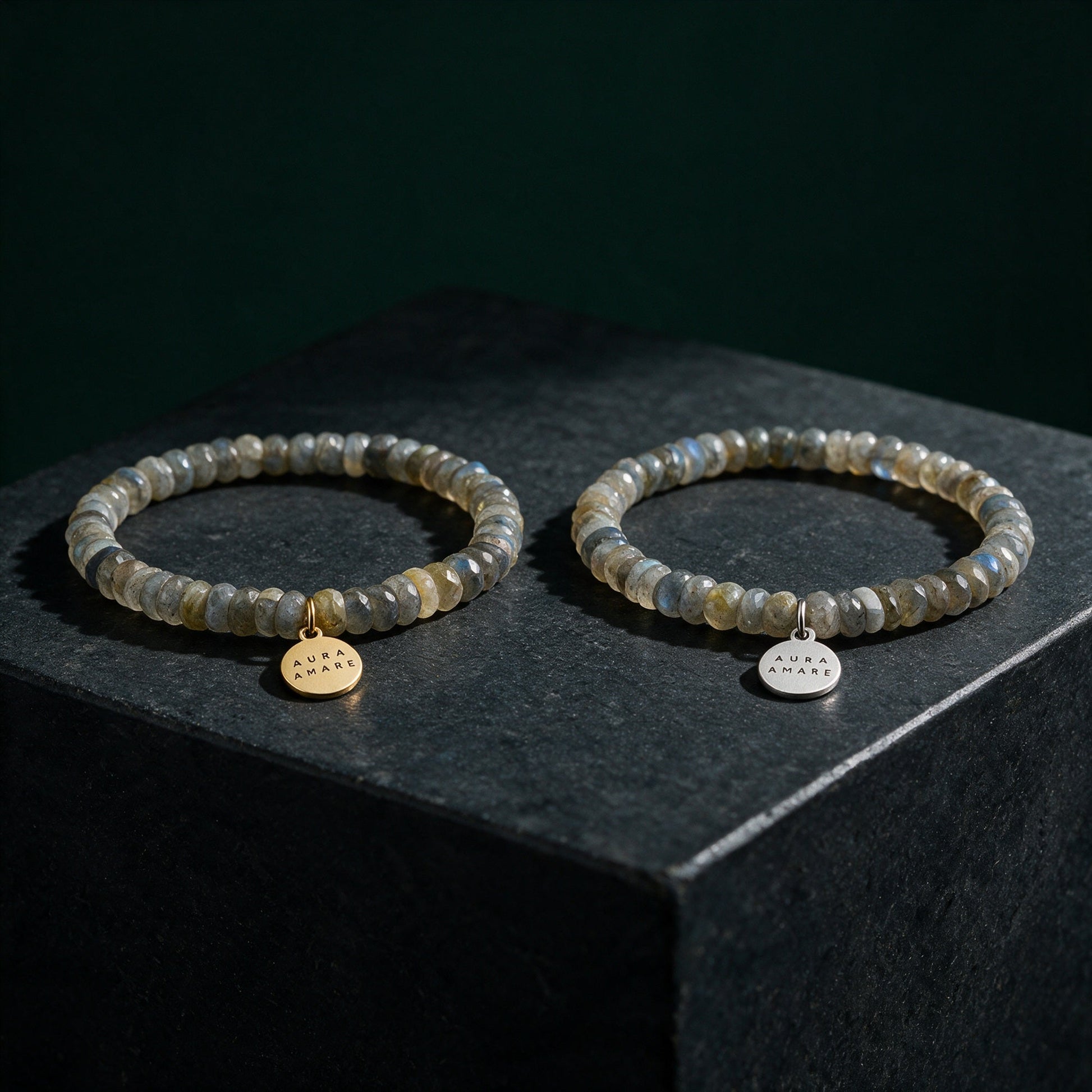 Labradorit Armband in Gold und Silber von AURA AMARE vor tiefem Smaragdgrün