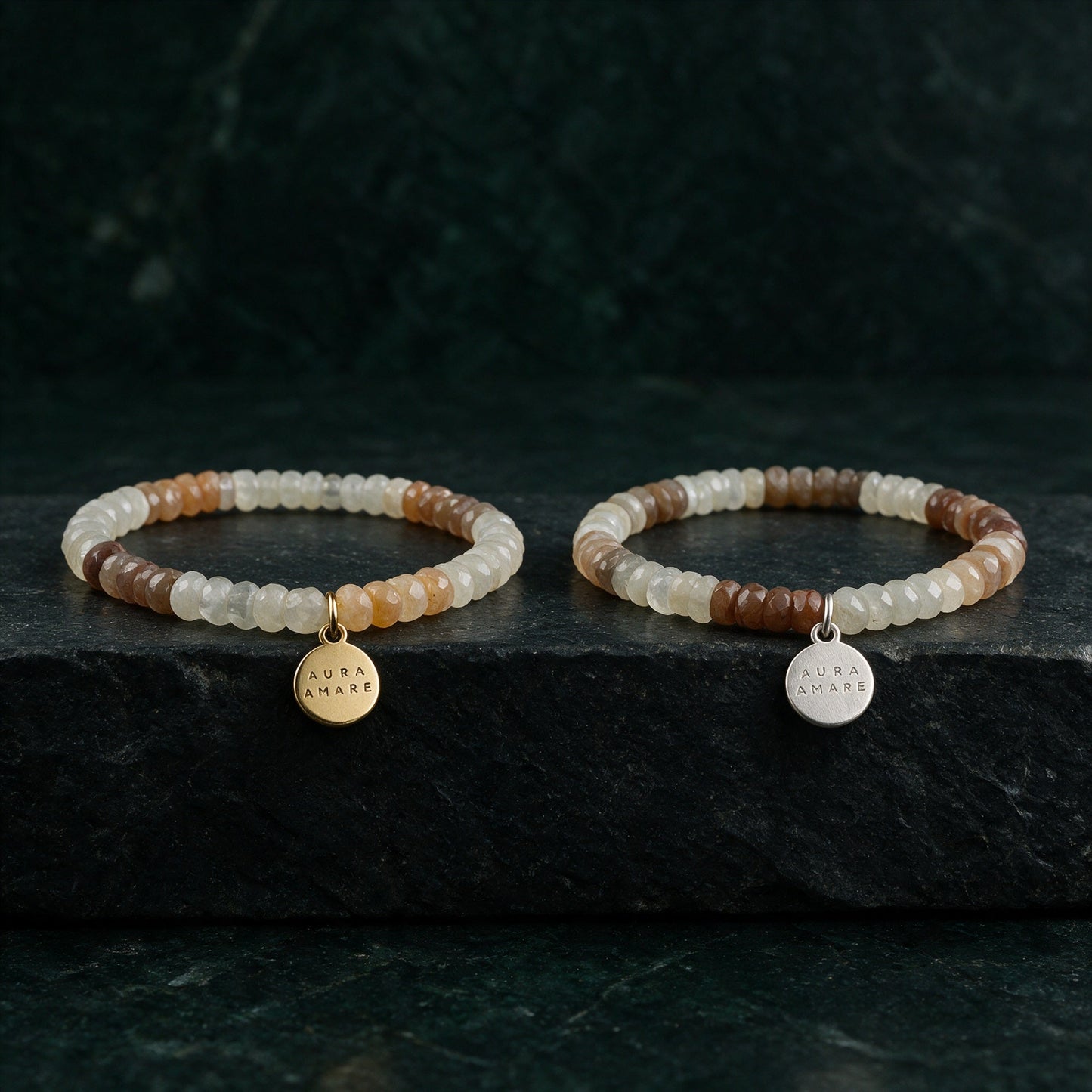 Mondstein Armband in Gold und Silber von AURA AMARE vor tiefem Smaragdgrün