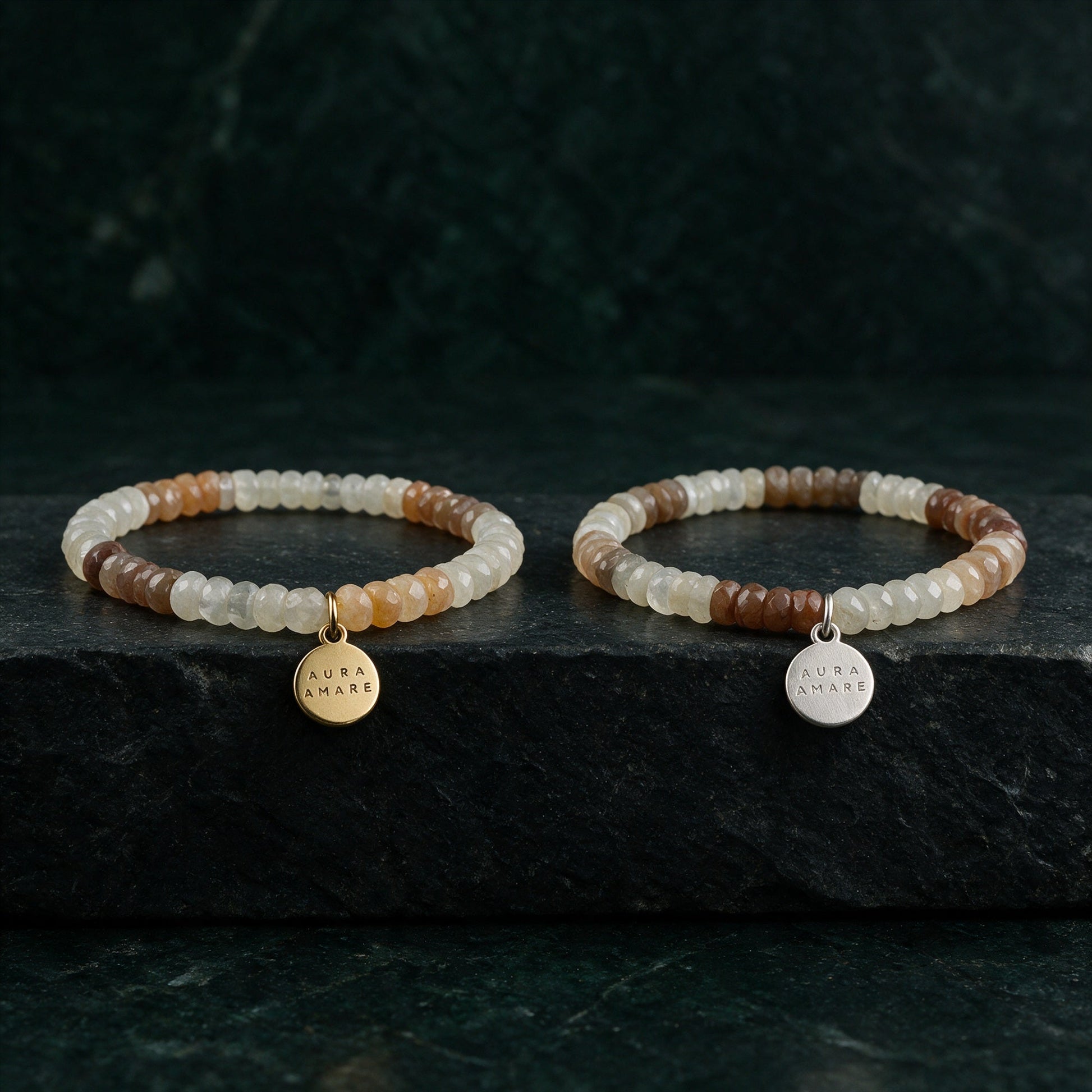 Mondstein Armband in Gold und Silber von AURA AMARE vor tiefem Smaragdgrün