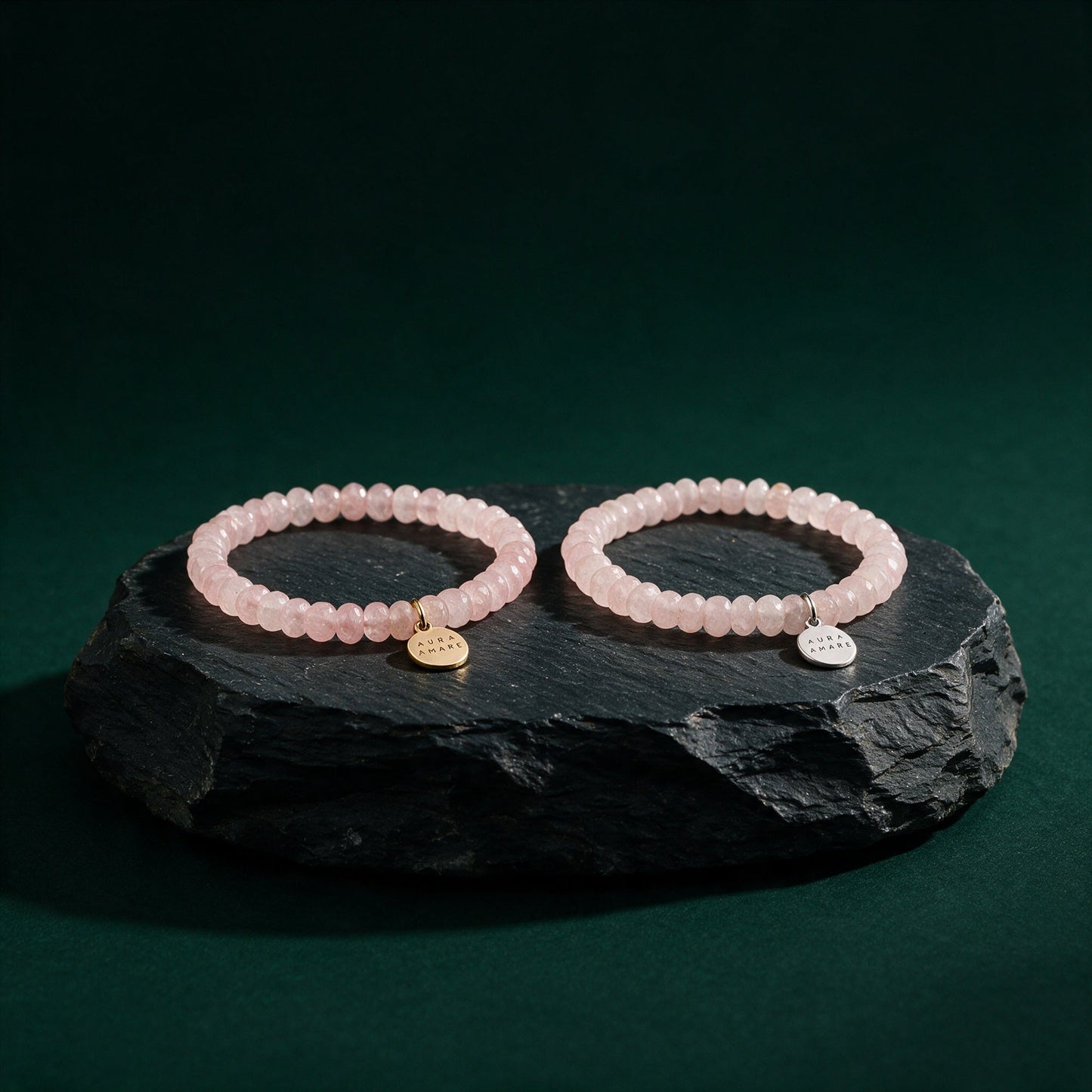 Rosenquarz Armband in Gold und Silber von AURA AMARE vor tiefem Smaragdgrün