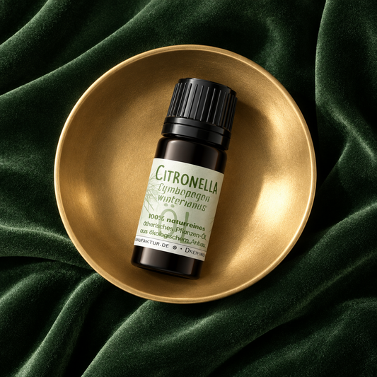 Citronella ätherisches Öl vor frischen Grashalmen