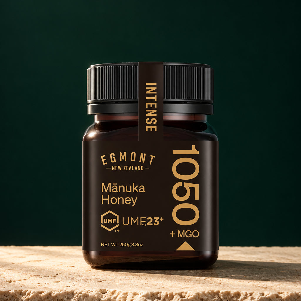 Glas Egmont Manuka Honey MGO 1050+ UMF 23+ auf hellem Stein vor dunkelgrünem Hintergrund