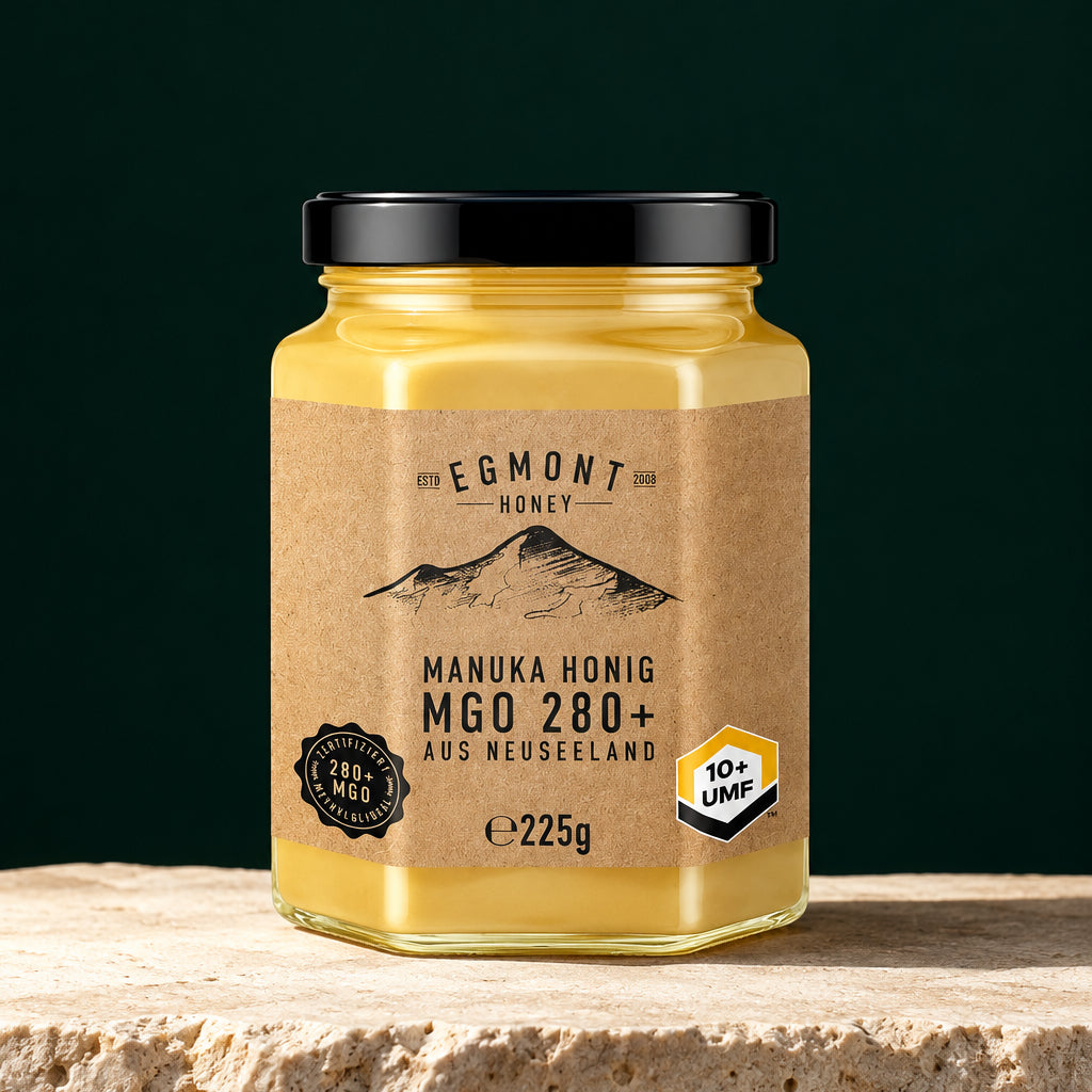 Egmont Honey MGO 280+ im Sechskantglas auf hellem Stein vor dunkelgrünem Hintergrund