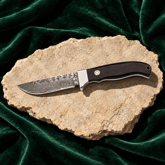 Herbertz Gürtelmesser mit Damastklinge und schwarzem Griff auf hellem Stein