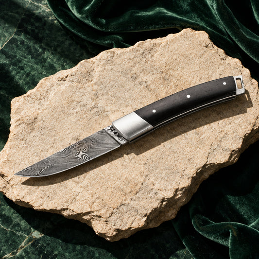 Fontenille Pataud Le Thiers Pocket mit Damastklinge und Ebenholzgriff auf hellem Stein