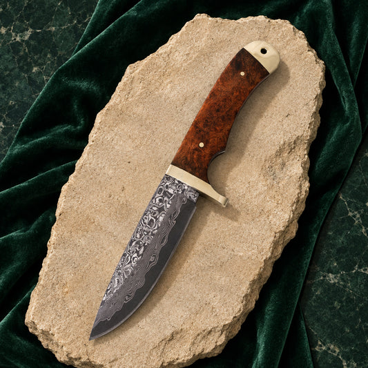 Damastmesser mit Wurzelholzgriff auf hellem Stein und grünem Samt